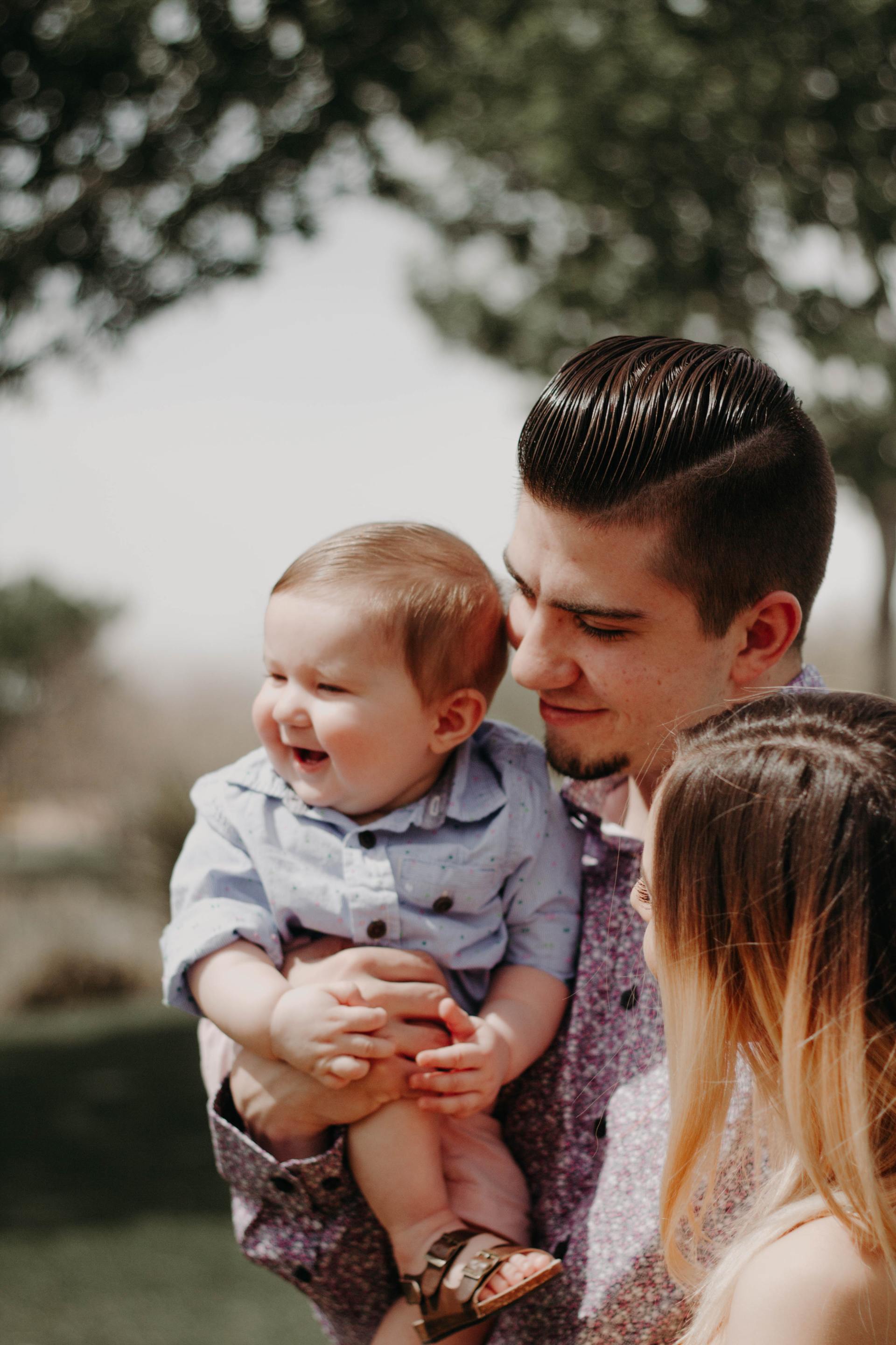 A man and woman are holding a baby in their arms.