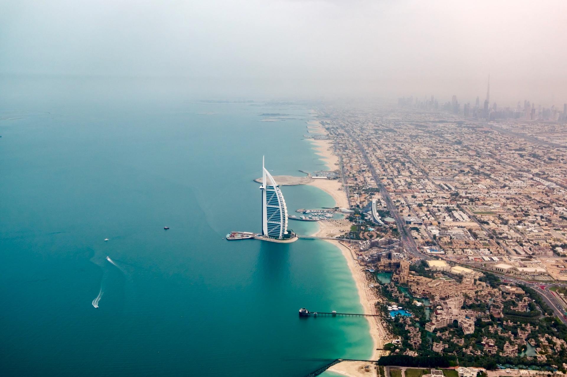 Eine Luftaufnahme von Dubai mit einem Segelboot mitten im Ozean.
