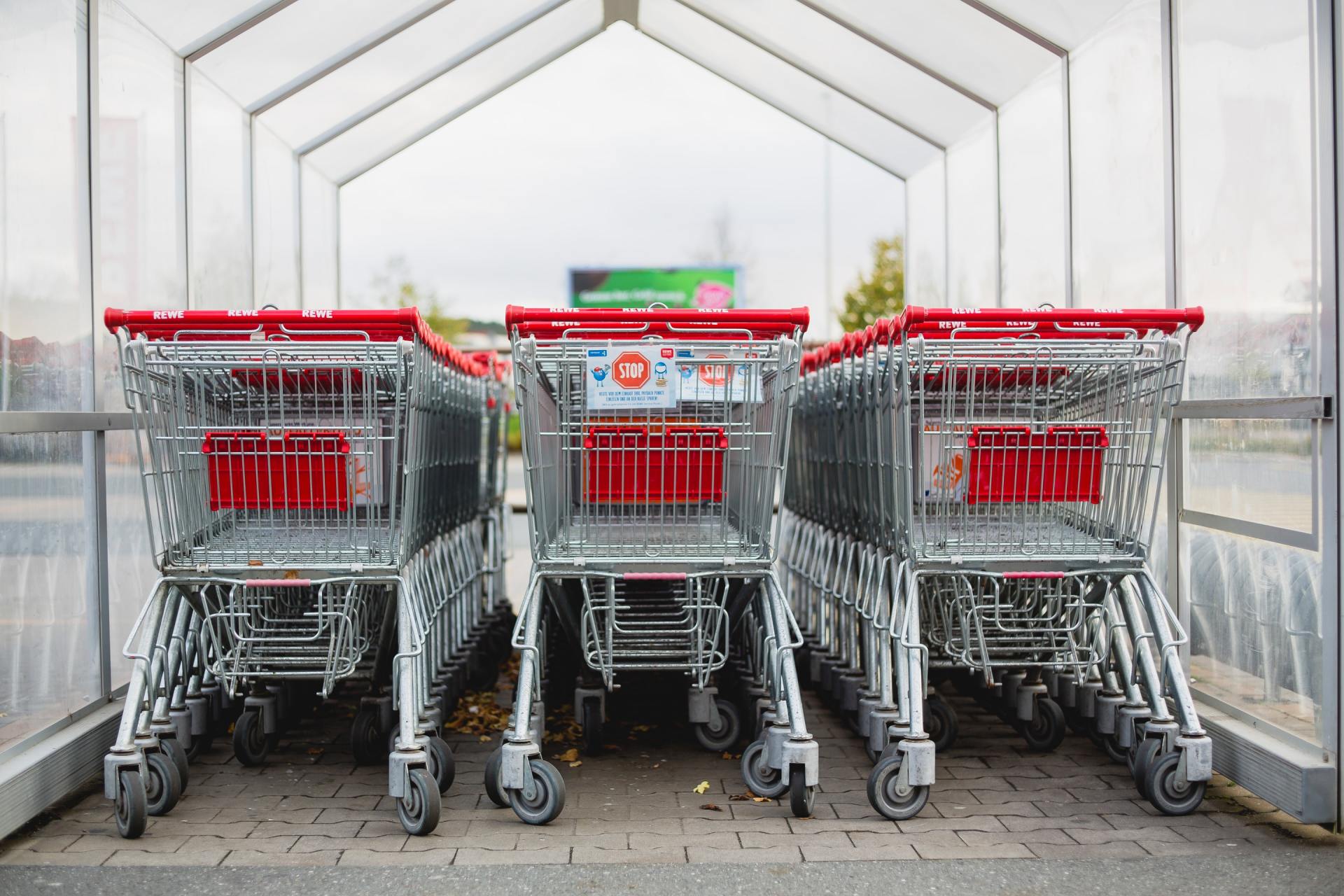 Una fila di carrelli della spesa sono allineati in un parcheggio.