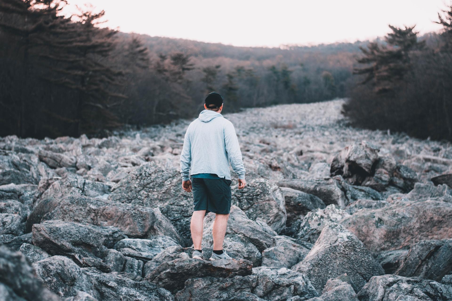 A man is standing on top of a pile of rocks.
