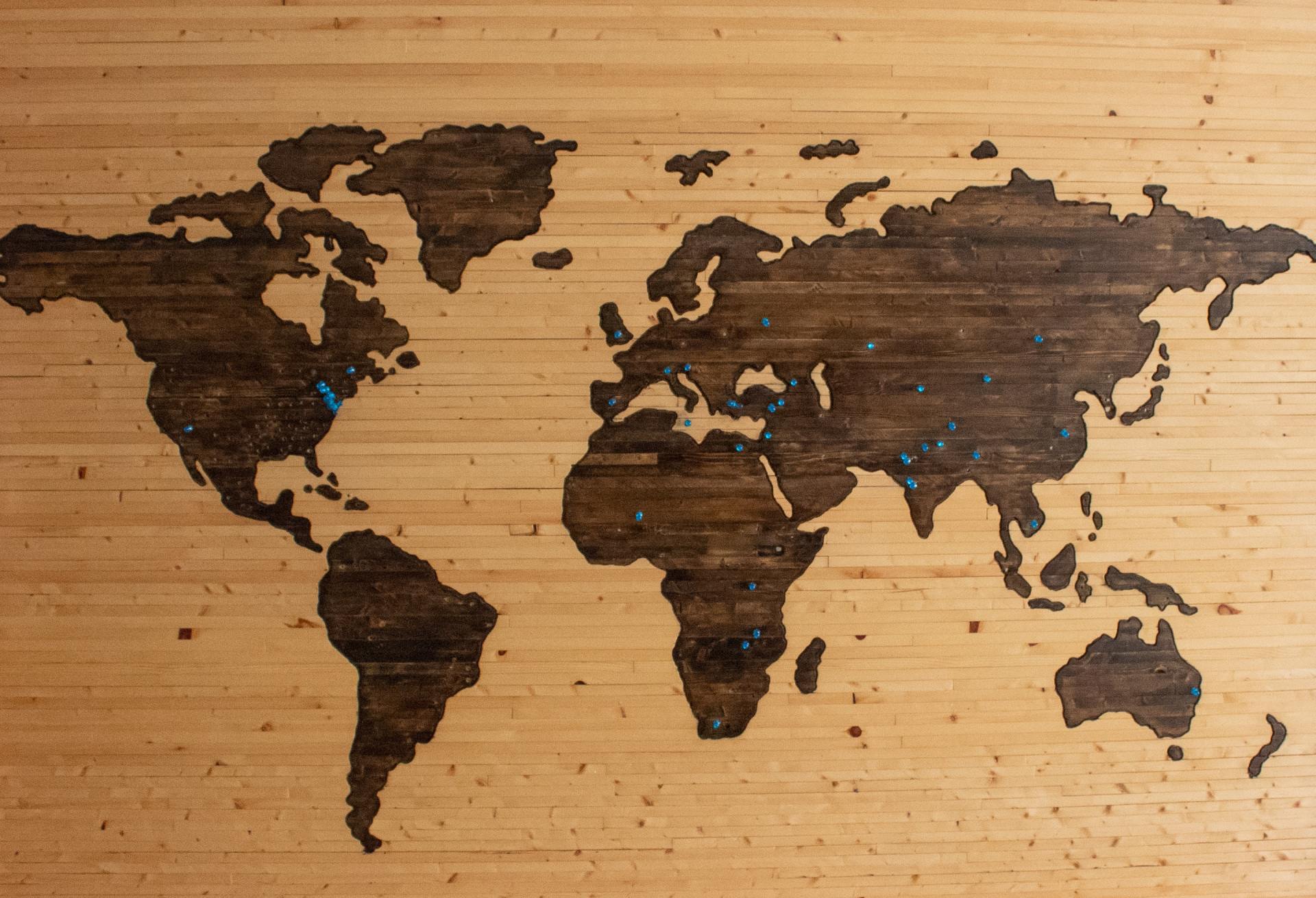 World map carved into a light-colored wooden surface.