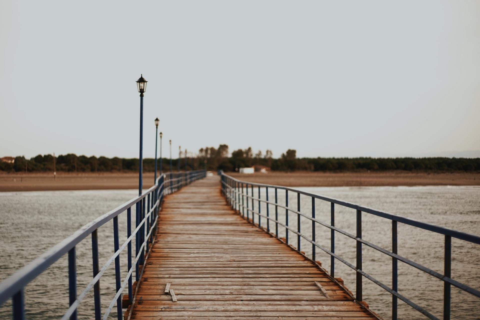 A long wooden pier leading to a body of water.
