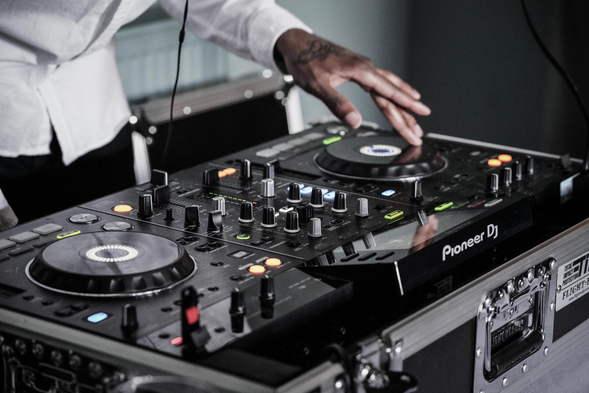 A dj is playing music on a pioneer dj controller.