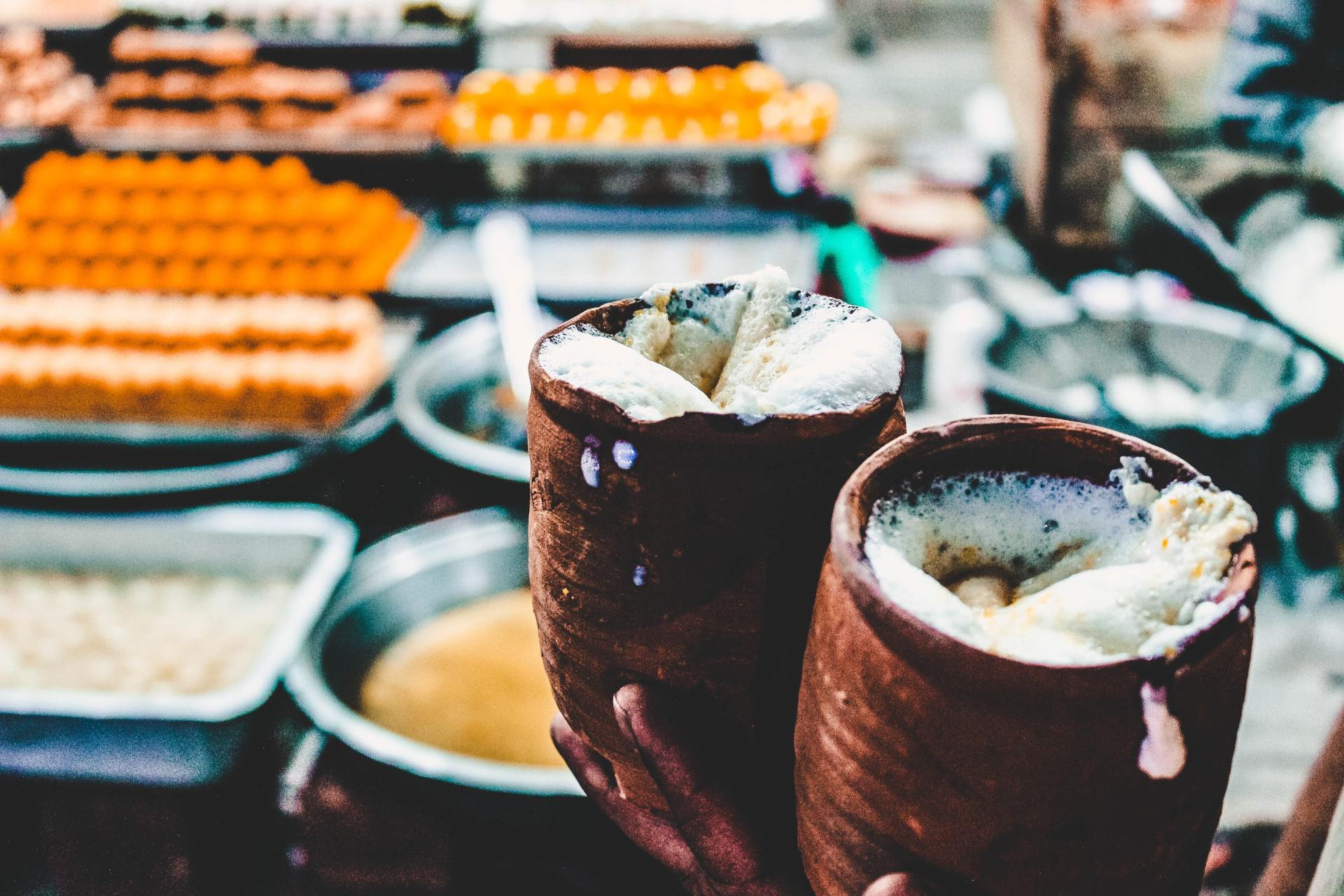 Une personne tient deux tasses de nourriture dans ses mains.