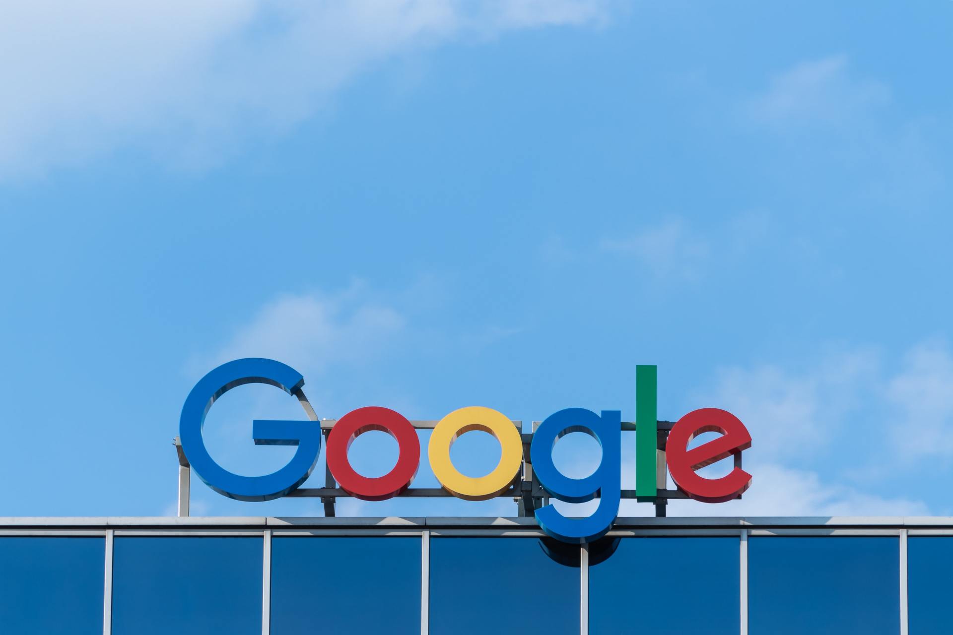 A google sign on top of a building with a blue sky in the background