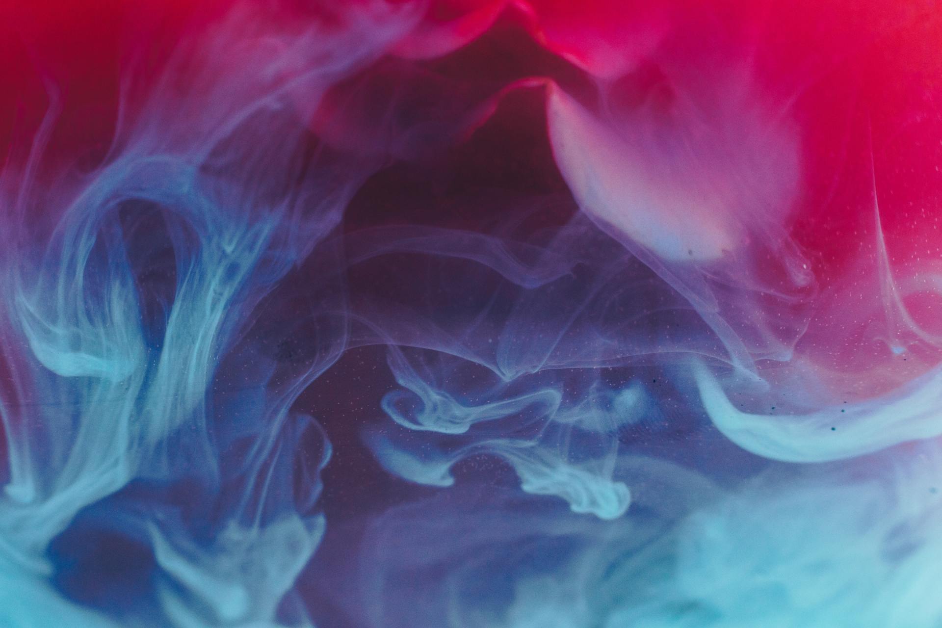 Abstract swirls of blue and pink smoke on a soft gradient background
