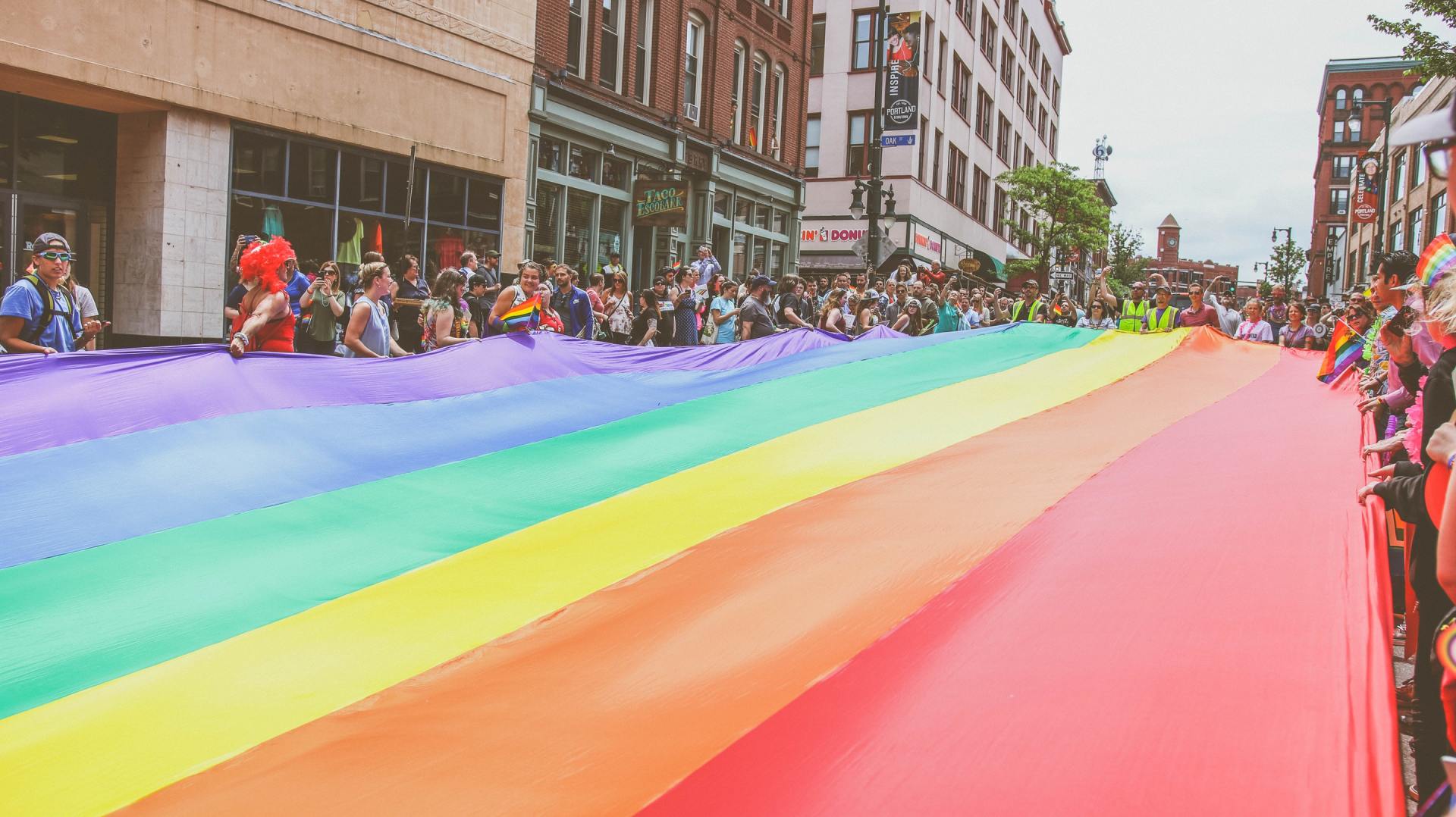 Photo of a rainbow banner stretch the length of Portland, ME, street