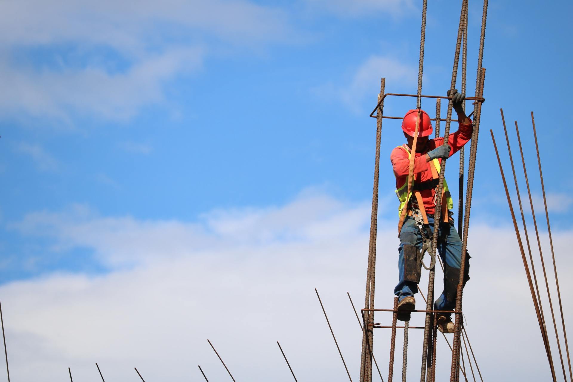 A construction worker is standing on top of a metal structure.