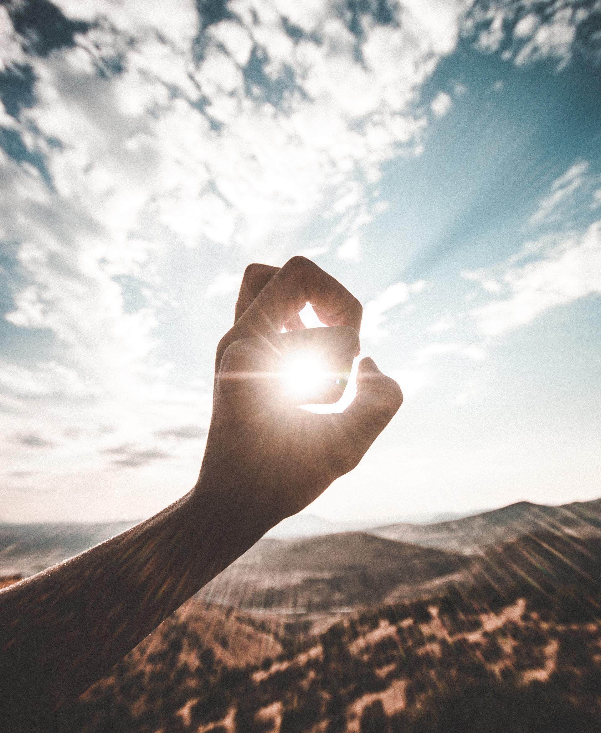 image of sun shining through hand