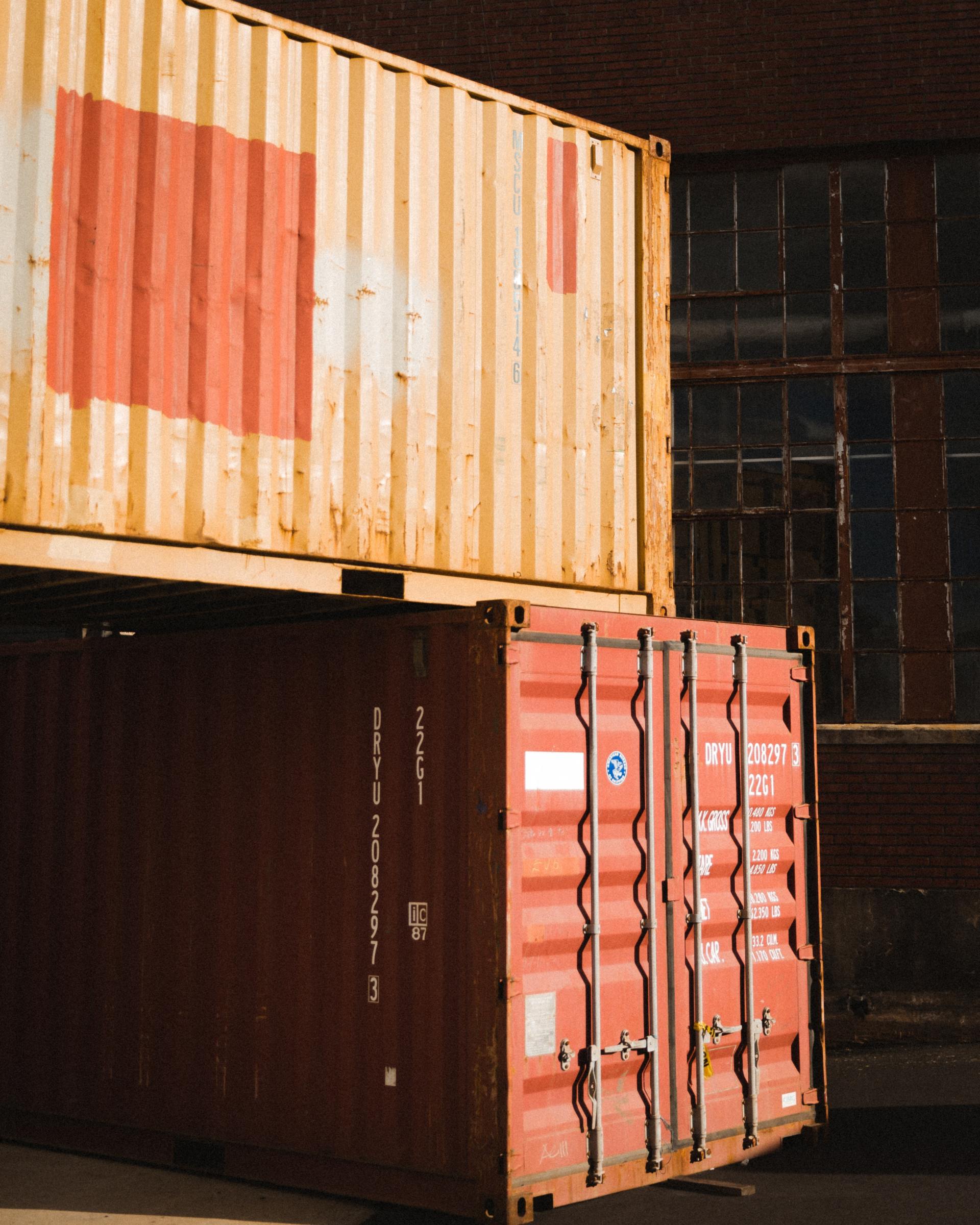 Two shipping containers are stacked on top of each other