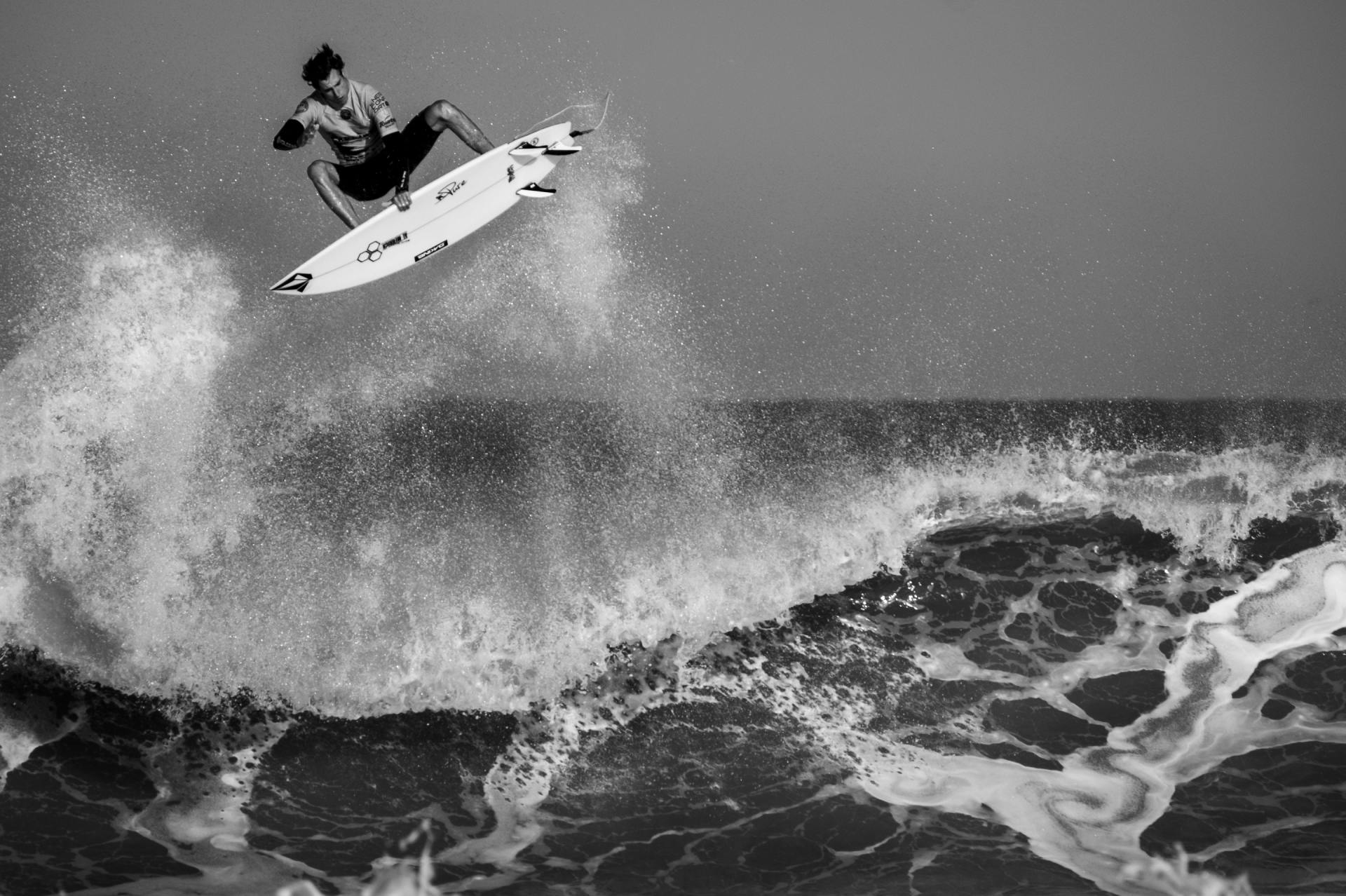 A surfer is jumping in the air while riding a wave