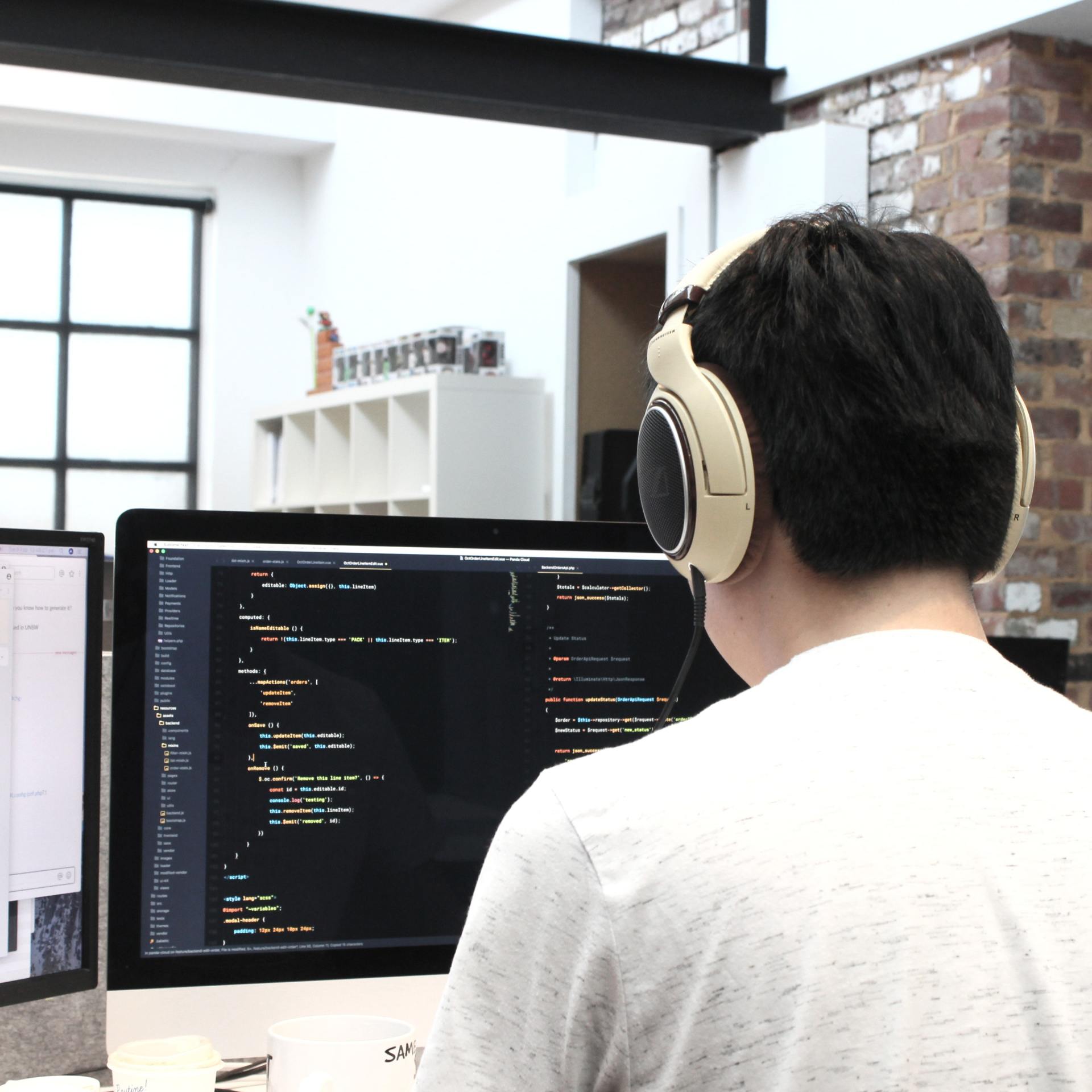 A man wearing headphones is working on a computer