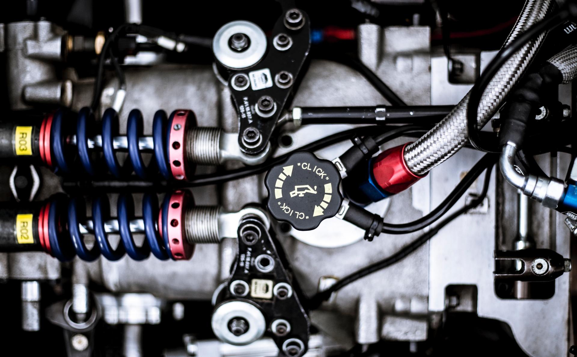 A close up of a car engine with a lot of wires coming out of it.