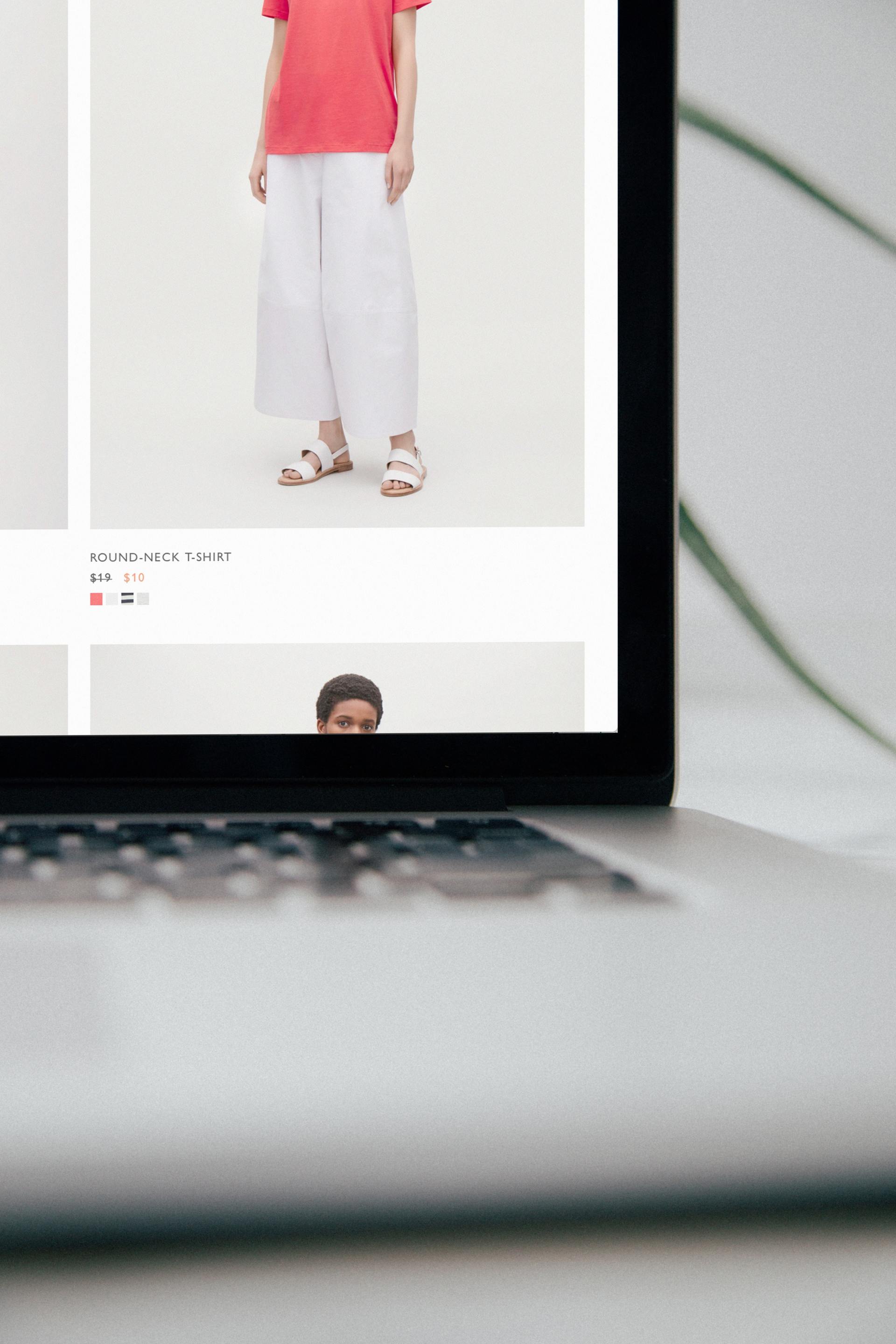 A laptop with a picture of a woman in a red shirt and white pants on the screen.