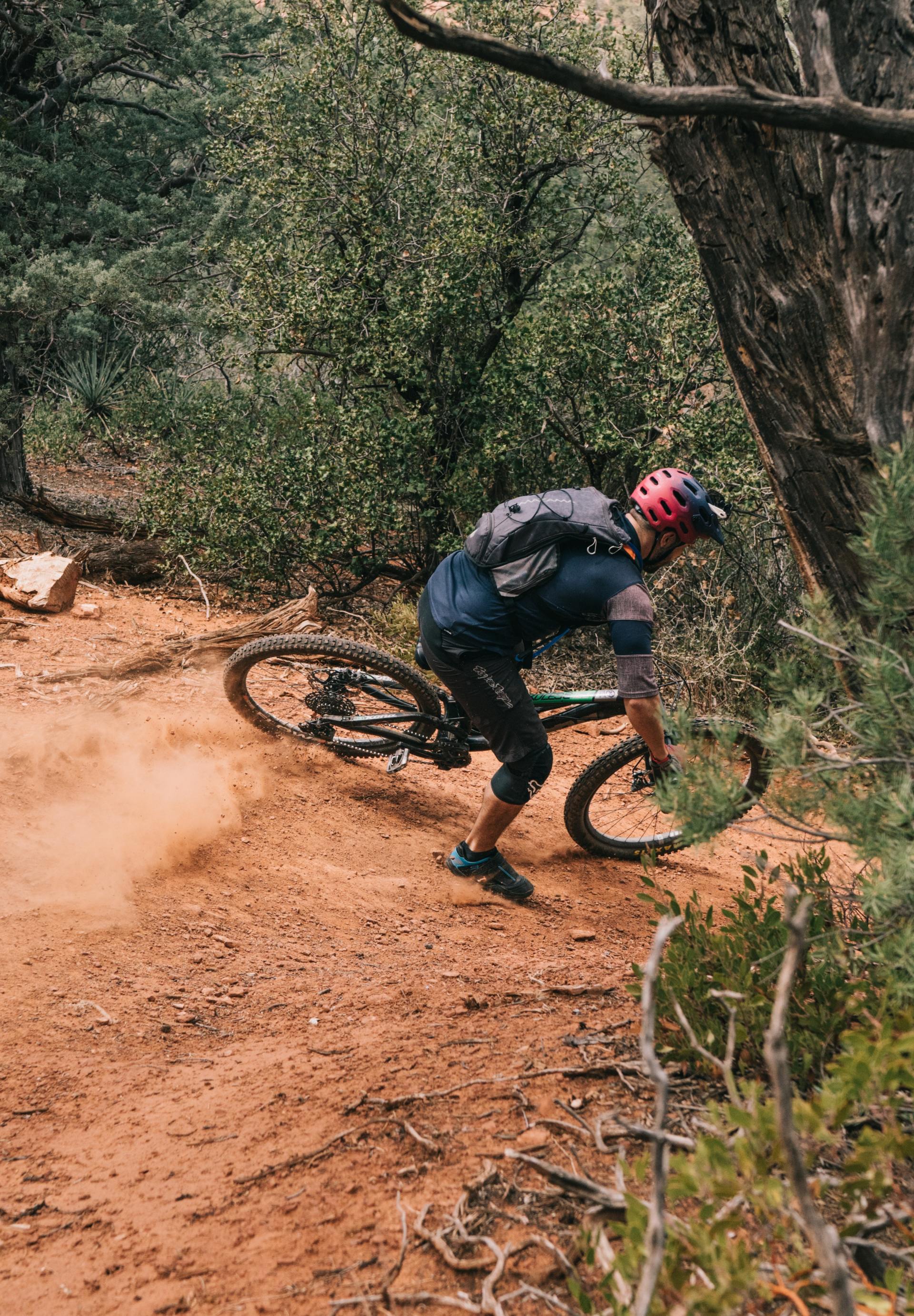 Een man rijdt op een mountainbike over een onverhard pad.