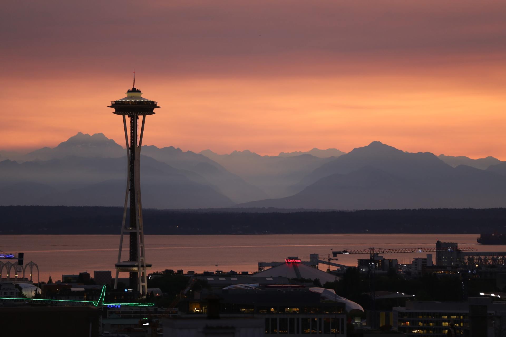A sunset over a city with the space needle in the foreground