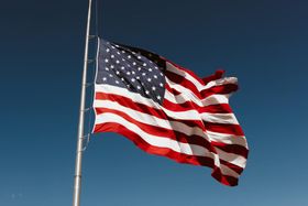 American flag waving on a pole against a clear blue sky