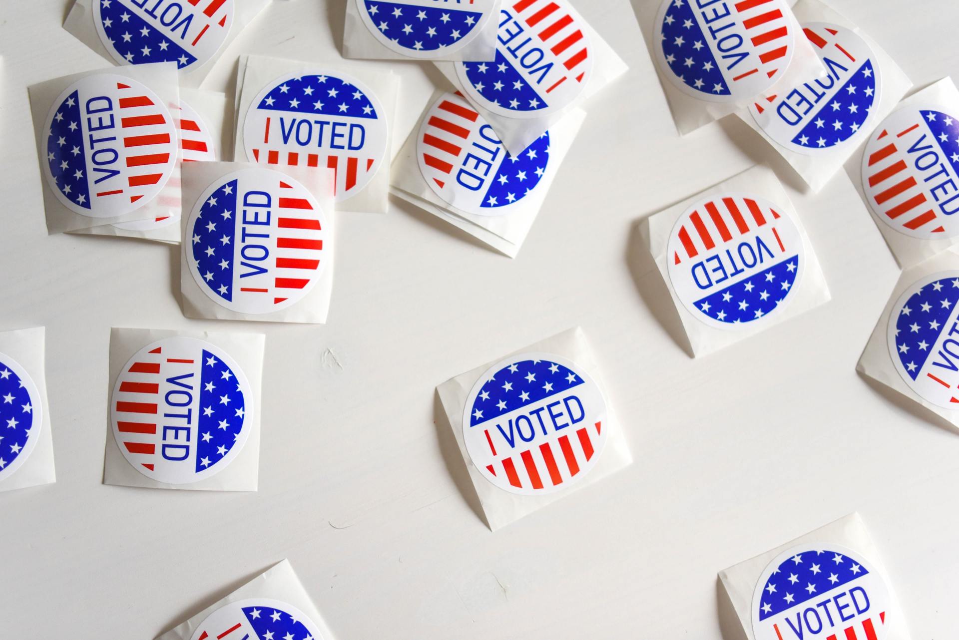 I voted stickers scattered on a white surface.
