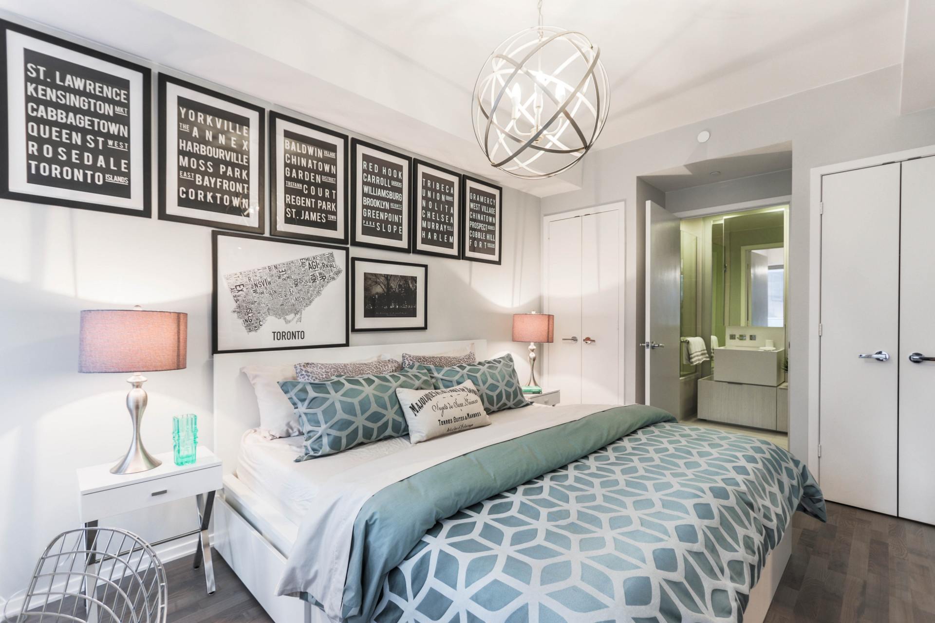 A bedroom with a large bed and a chandelier
