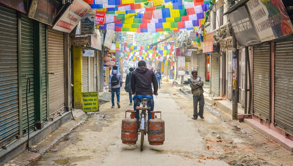 Man riding a bike down a dirty street