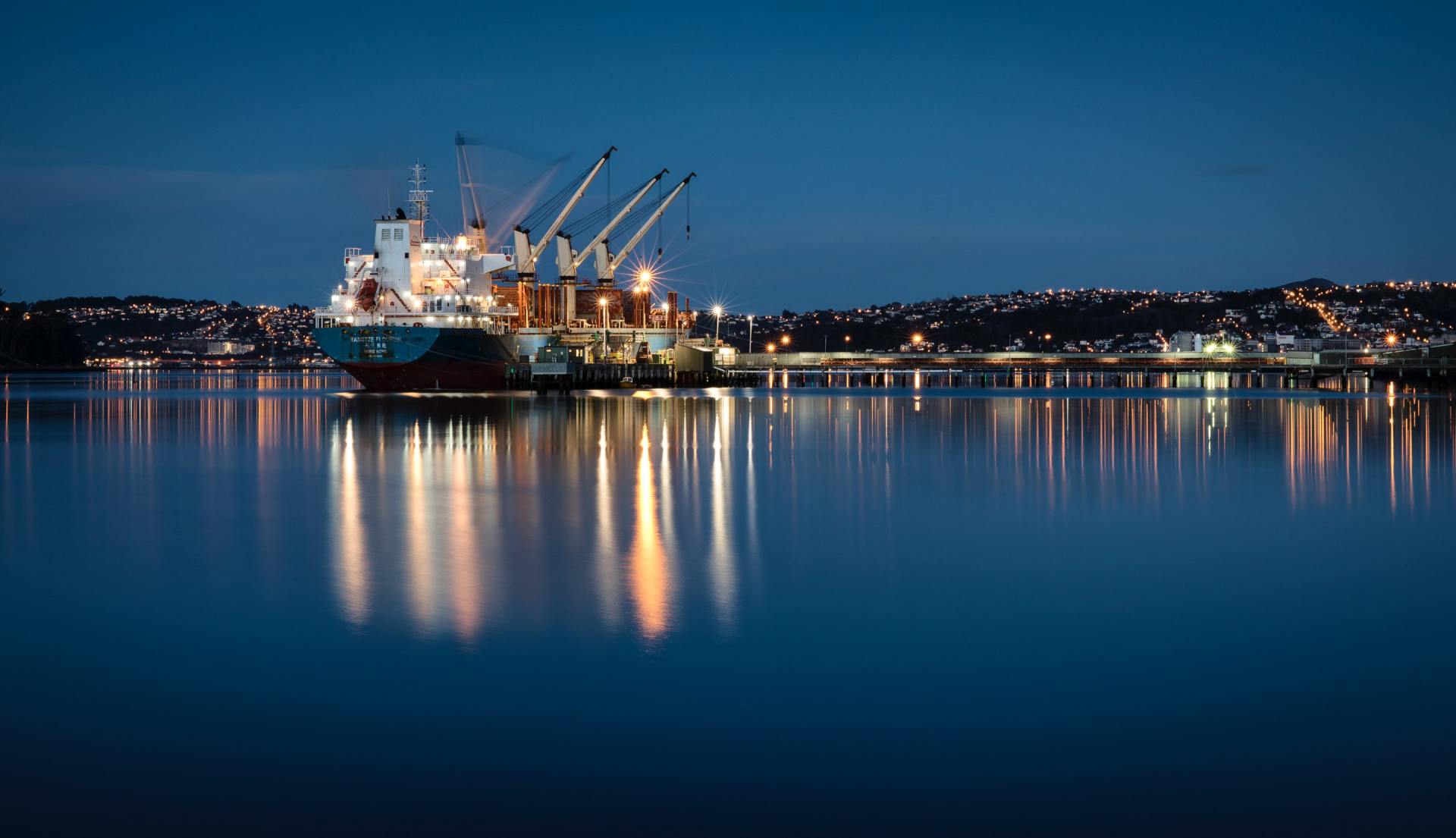 a large ship is docked in a harbor at night .