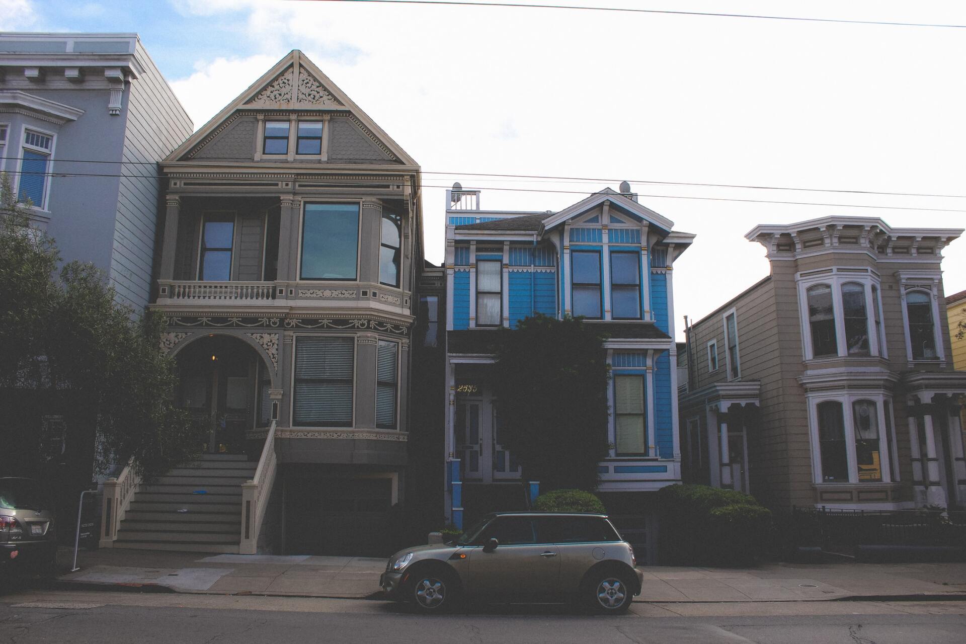 A car is parked in front of a row of houses