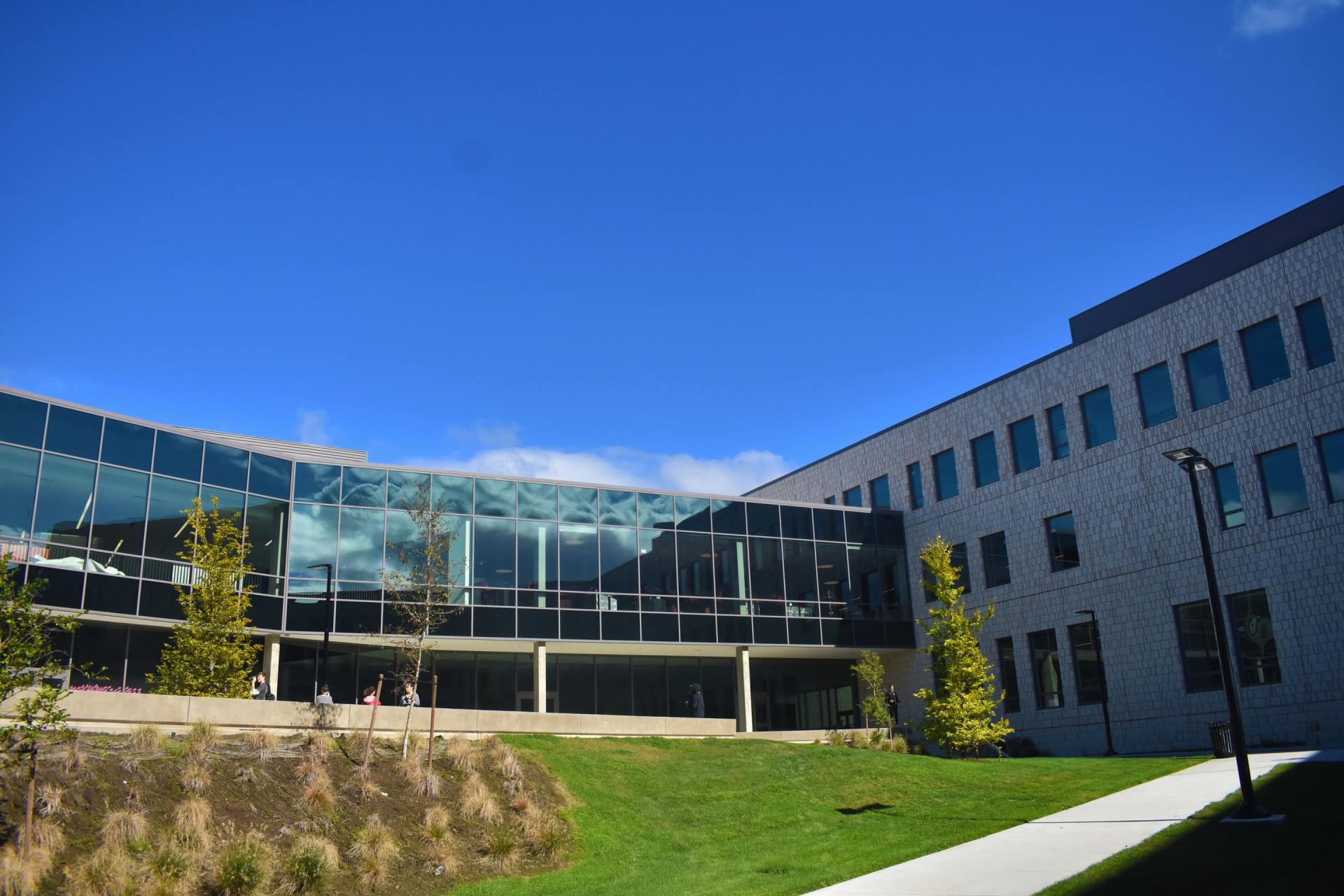 College Campass with a large grassy area & bright clear blue sky above the school