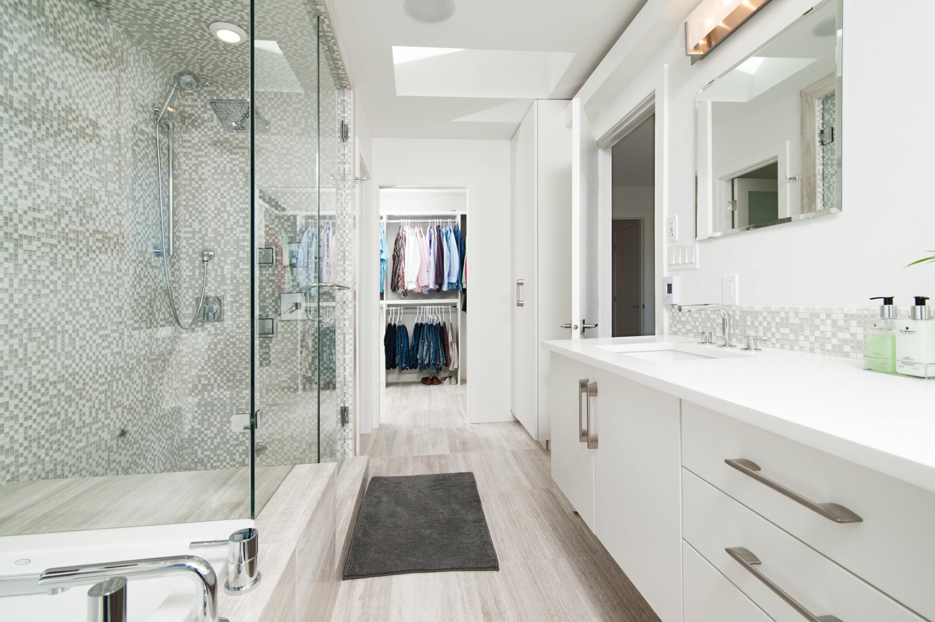 A bathroom with a walk in closet and a bathtub.