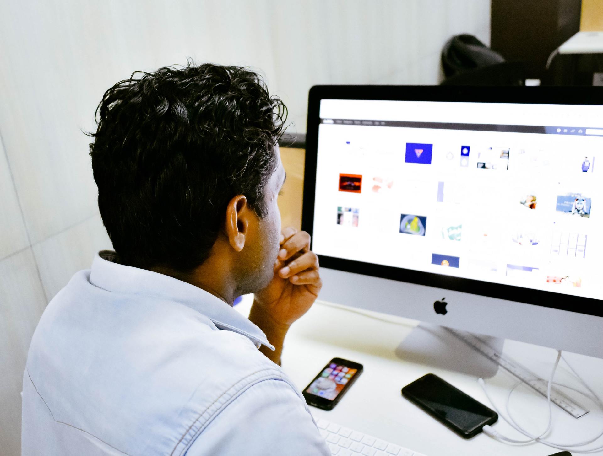 A man is sitting in front of an apple computer