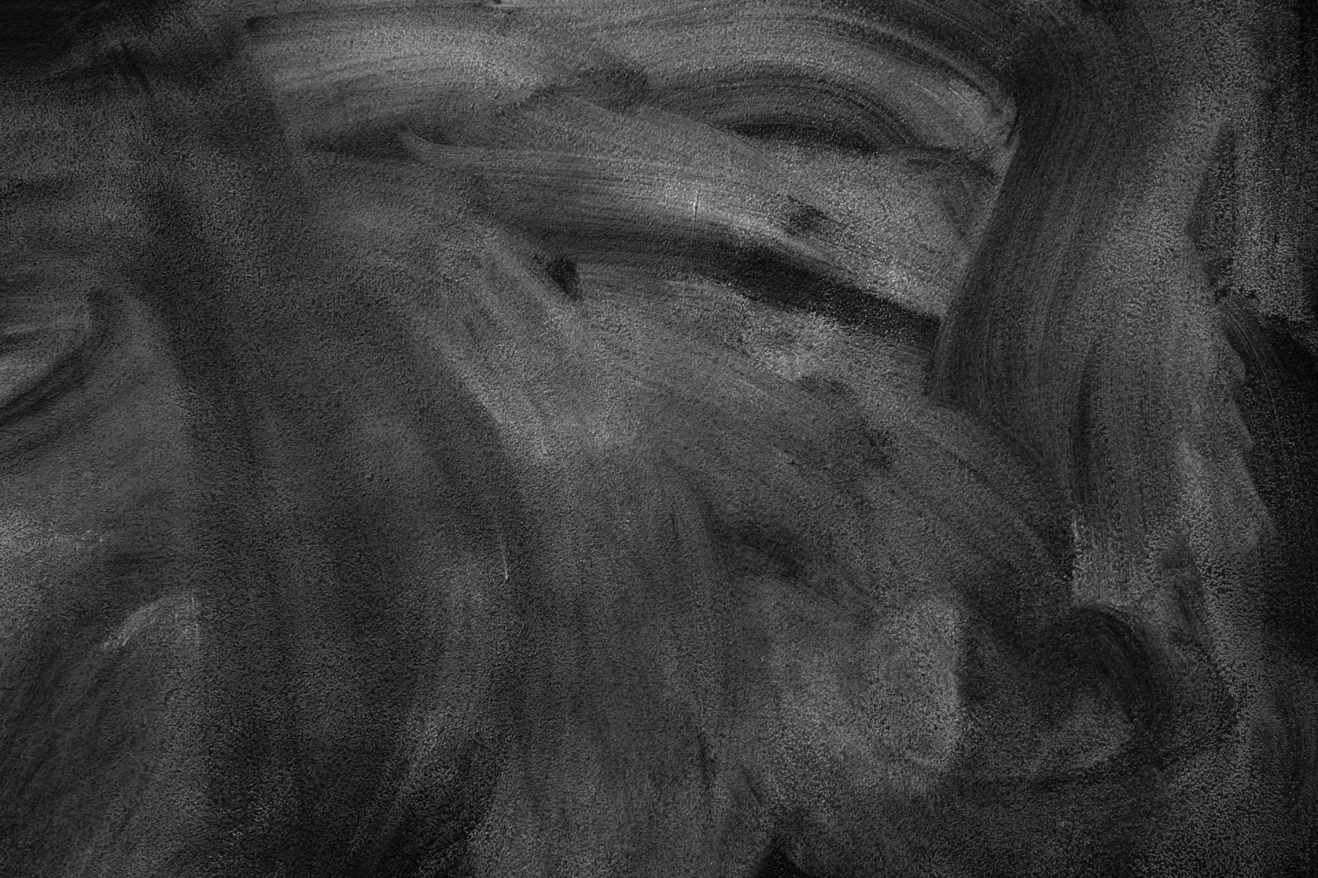 Black and white textured background with visible brushstrokes creating abstract patterns.
