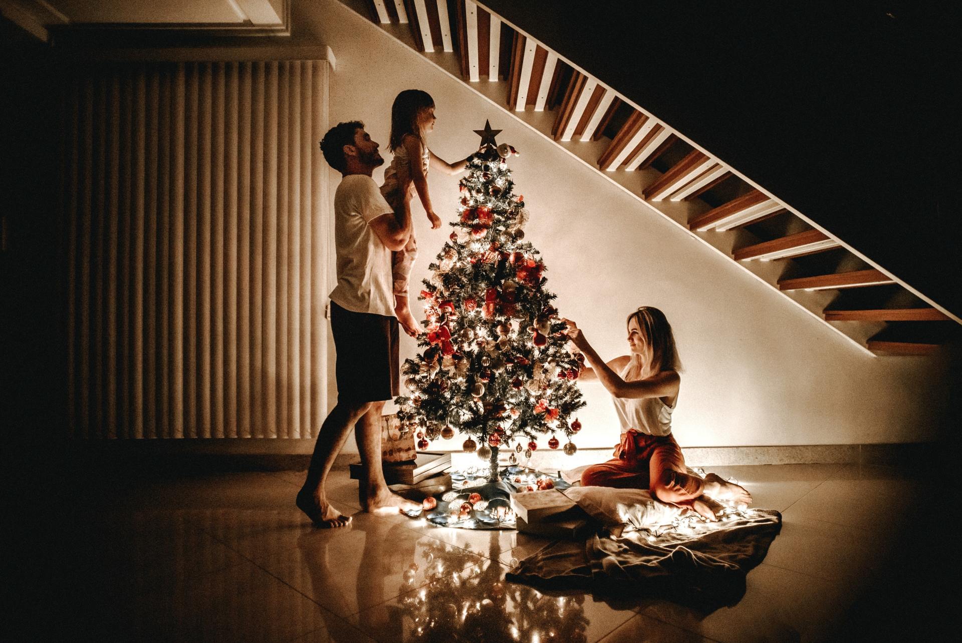 Family at Christmas putting decorations on the tree.