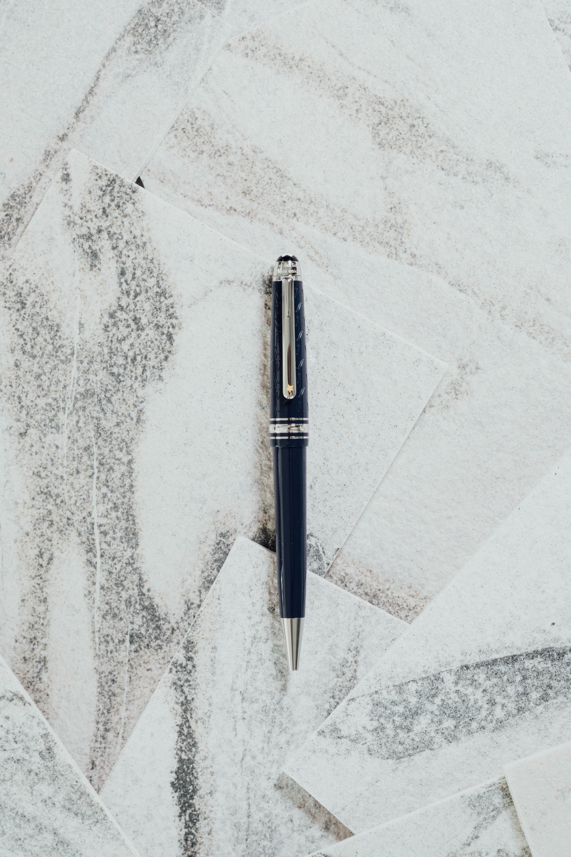 Un stylo est posé sur une surface blanche.