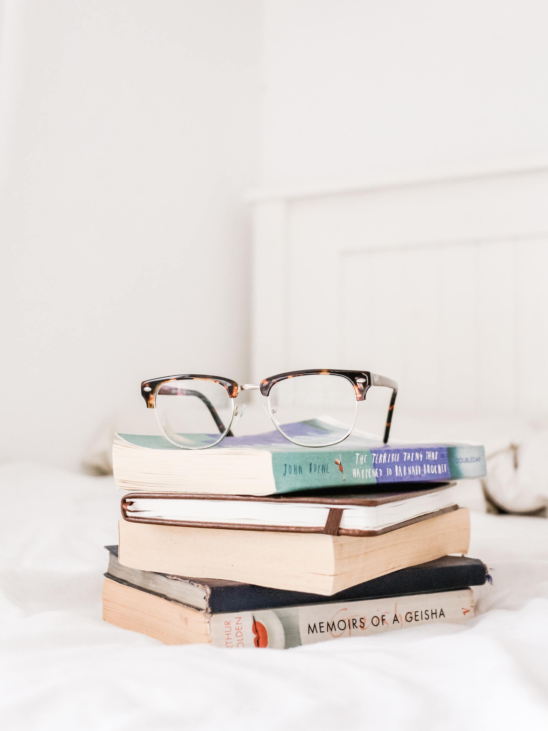 Bild für Social Media: Bücherstapel mit Brille