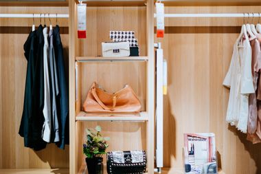 A closet filled with clothes and a purse.
