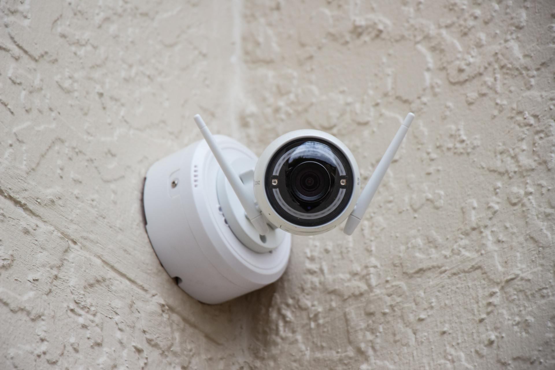 A security camera is mounted on the side of a building.