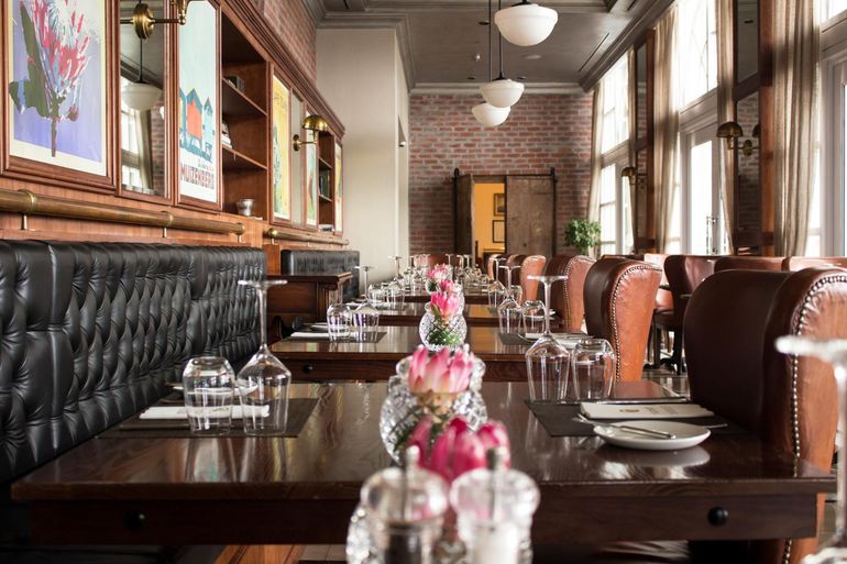 a restaurant filled with tables and chairs and a brick wall .