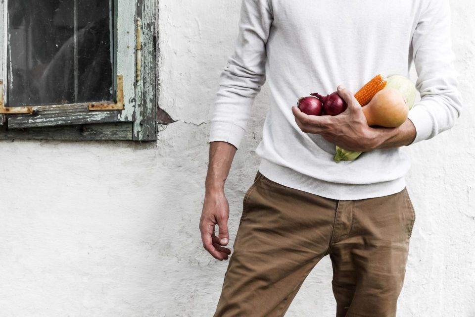 Man carrying vegetables near a building