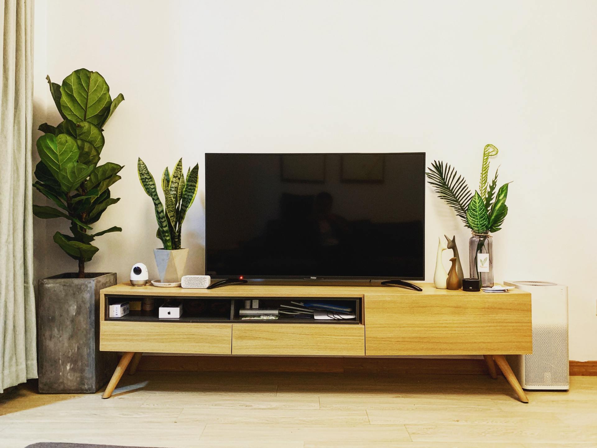 A flat screen tv is sitting on top of a wooden entertainment center in a living room.