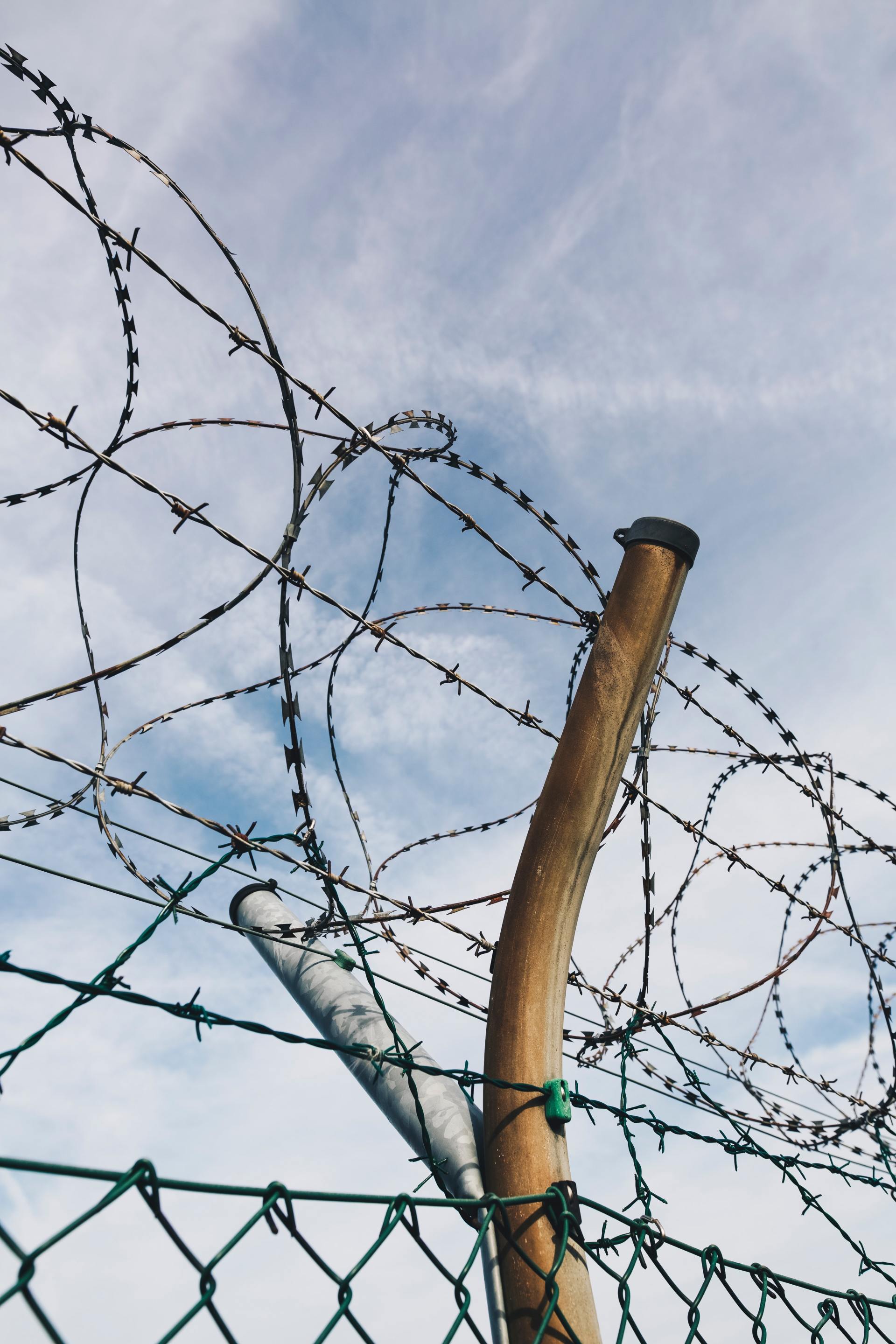 A barbed wire fence with a blue sky in the background