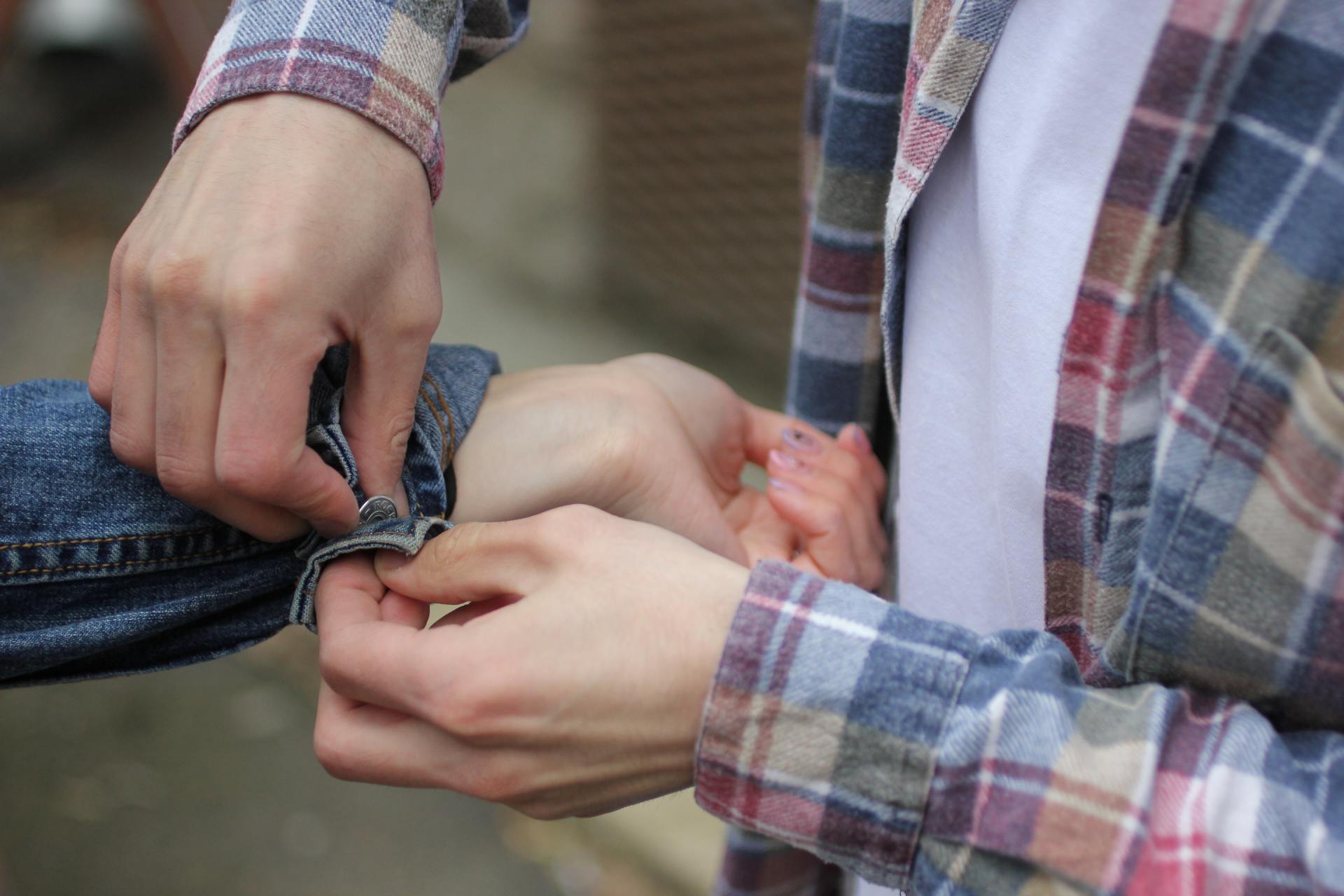 Helping by buttoning someone else's sleeve