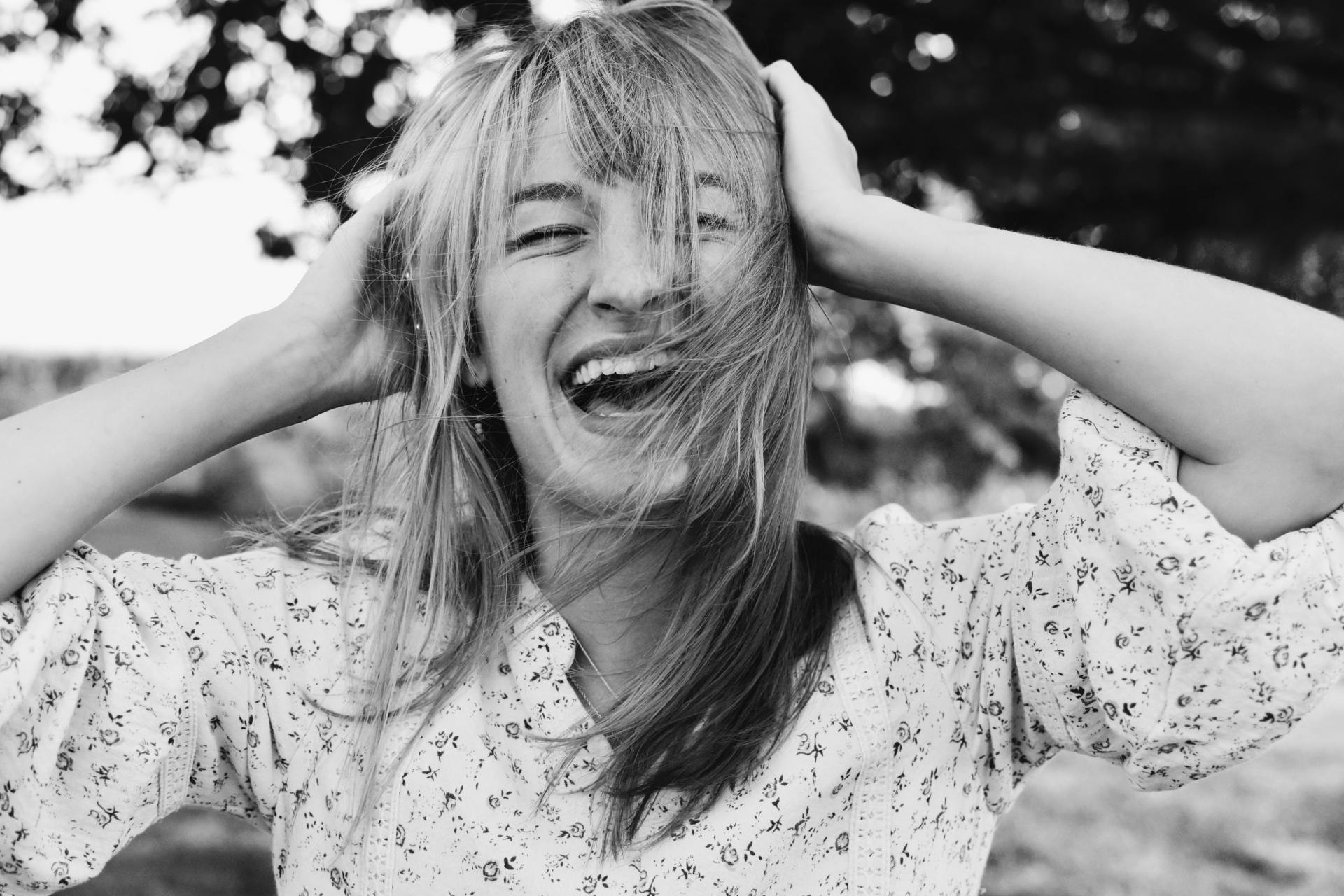 woman laughing hands on head