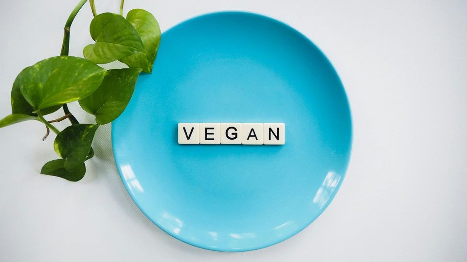 Blue Plate with the word VEGAN spelled out in Scrabble tiles