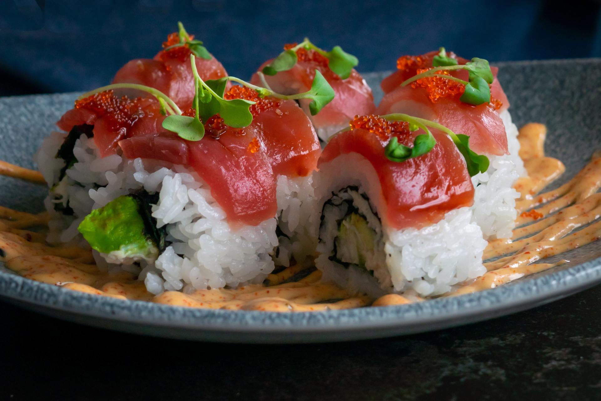 A close up of a plate of sushi on a table.