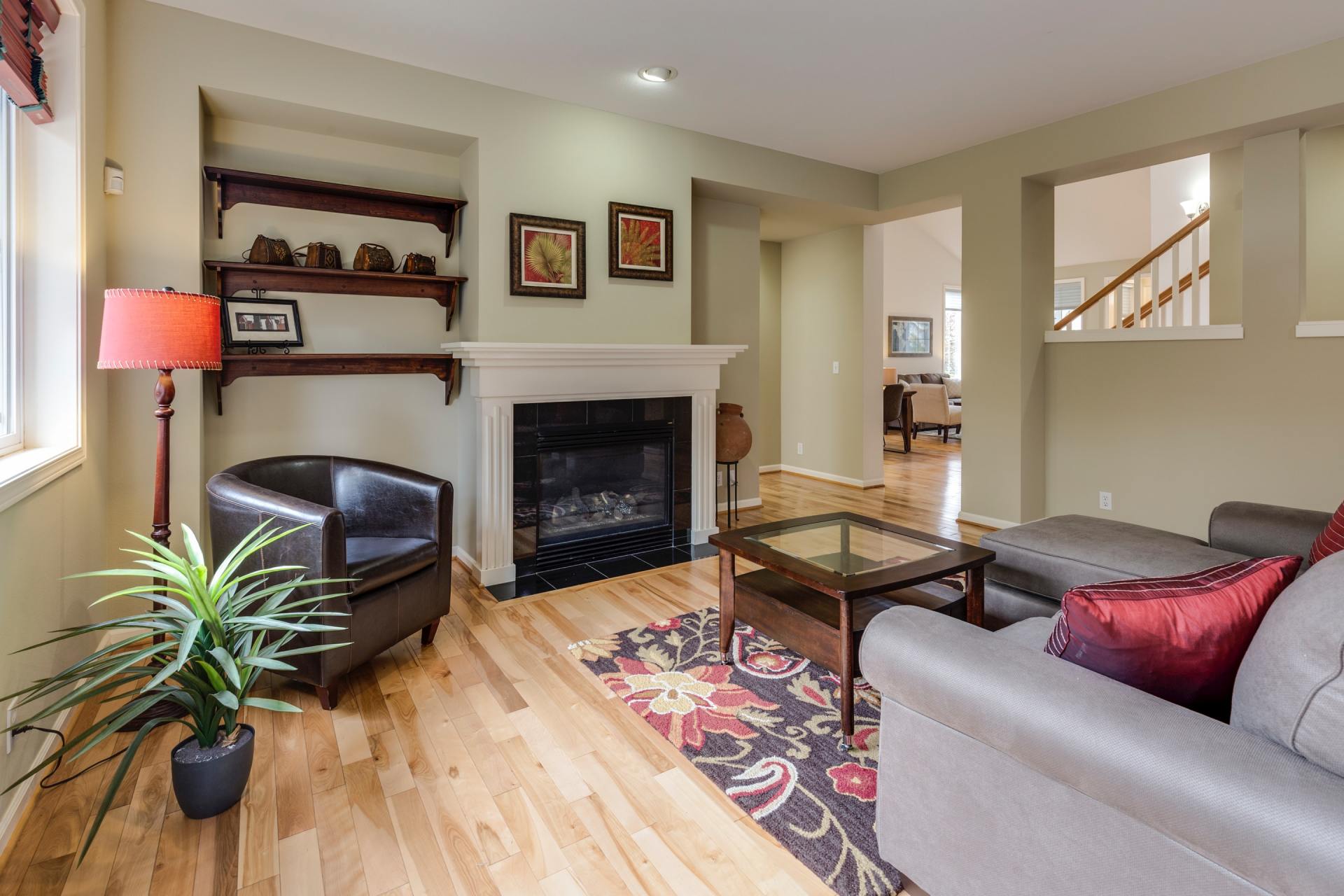 A living room with a couch , chair , coffee table and fireplace.