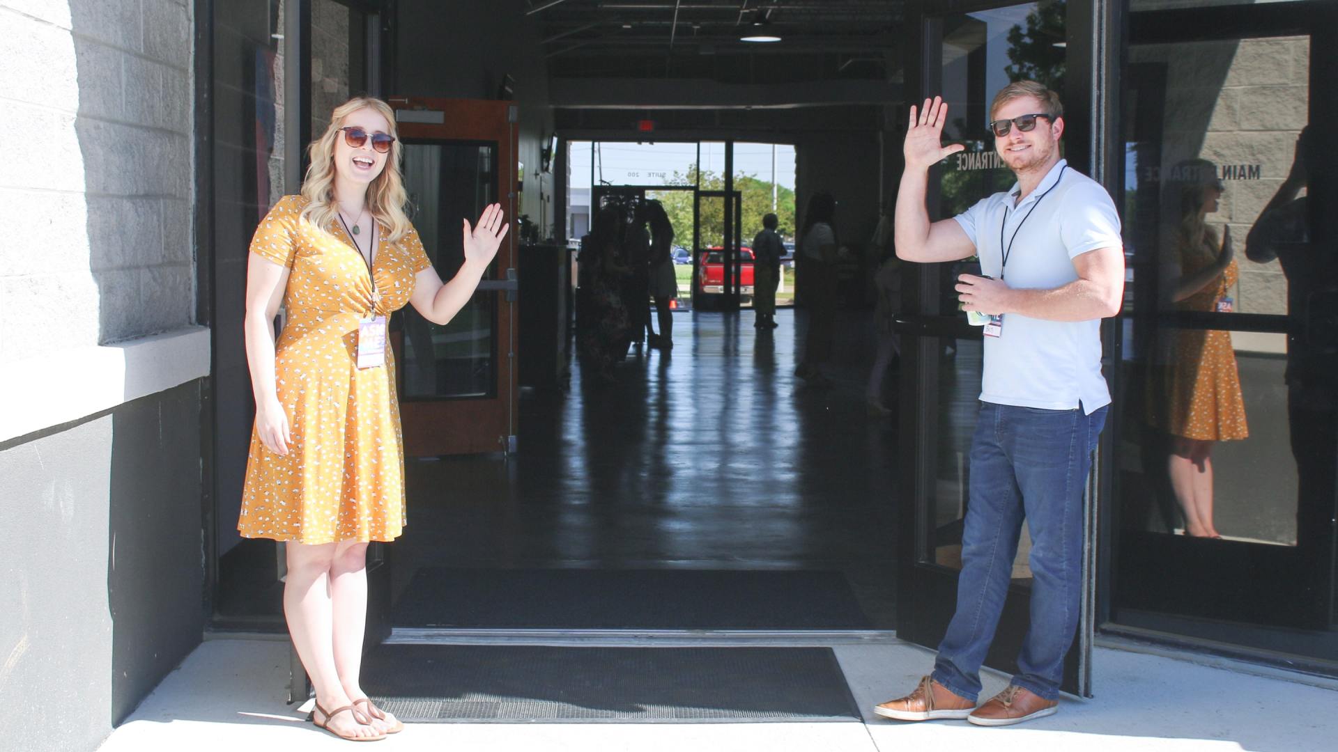 A man and a woman are standing in front of an open door.