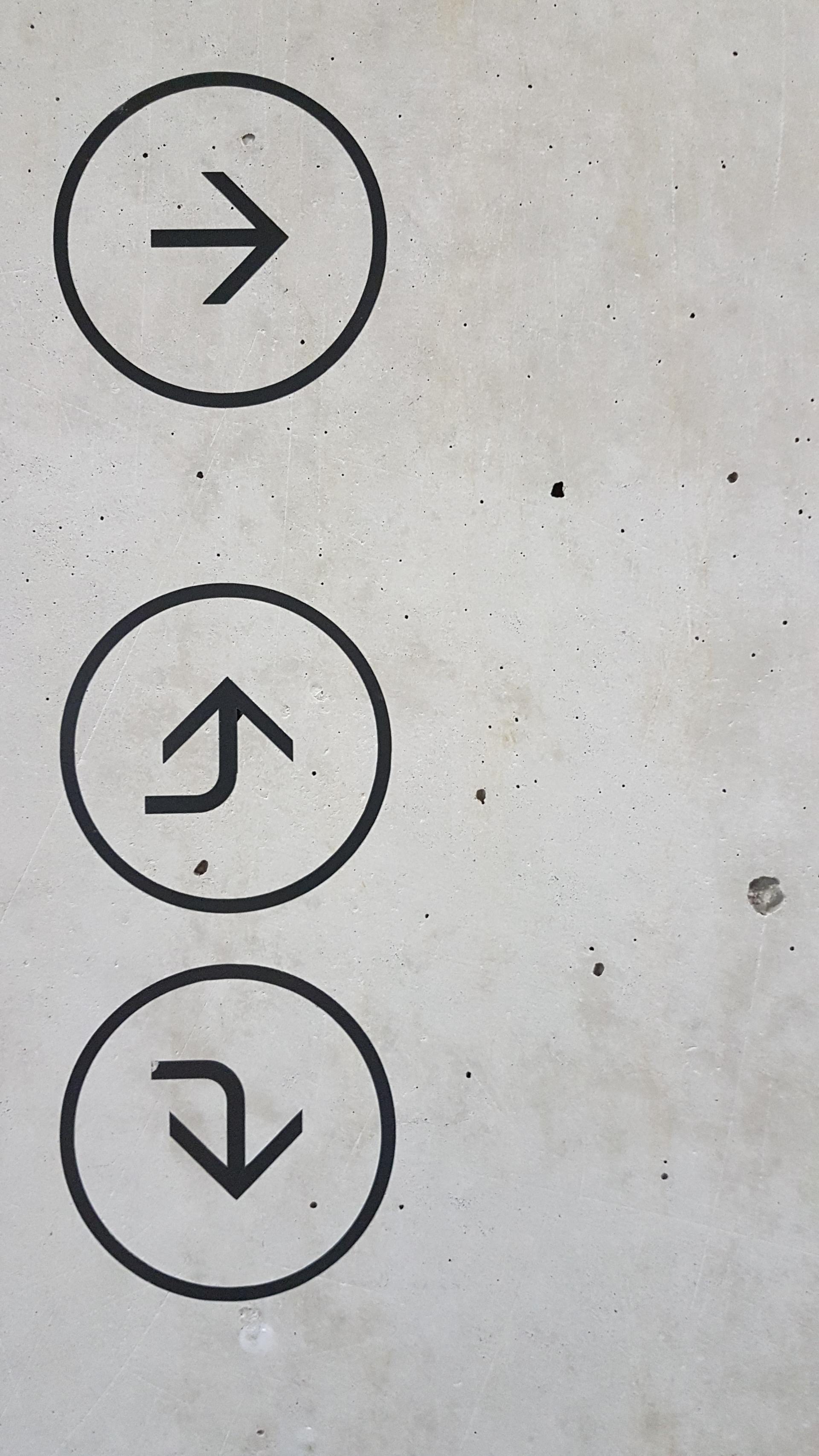 three black arrows on wall one points to right one points up and one points down