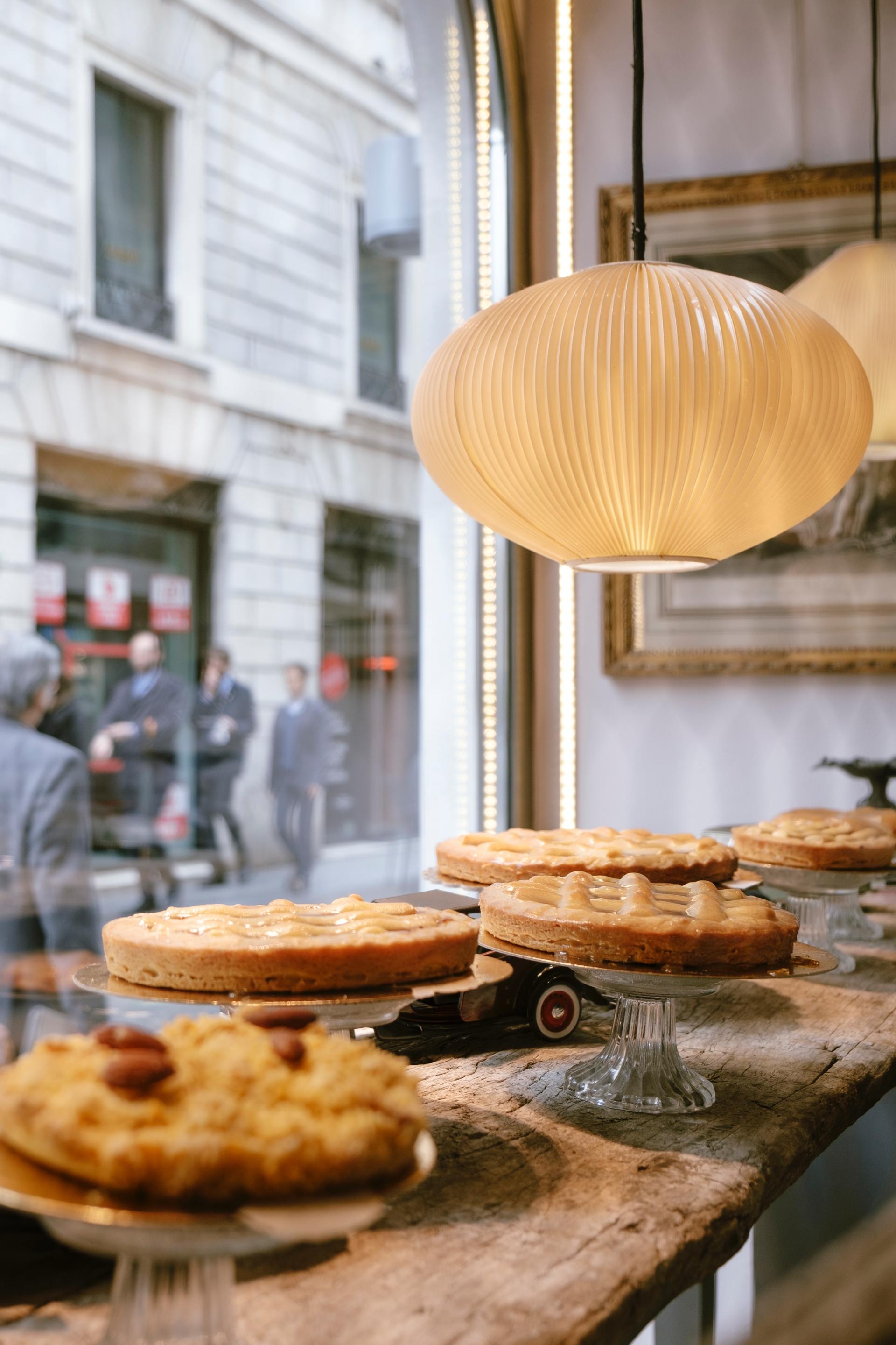 A bakery with a lot of pastries on display in front of a window.