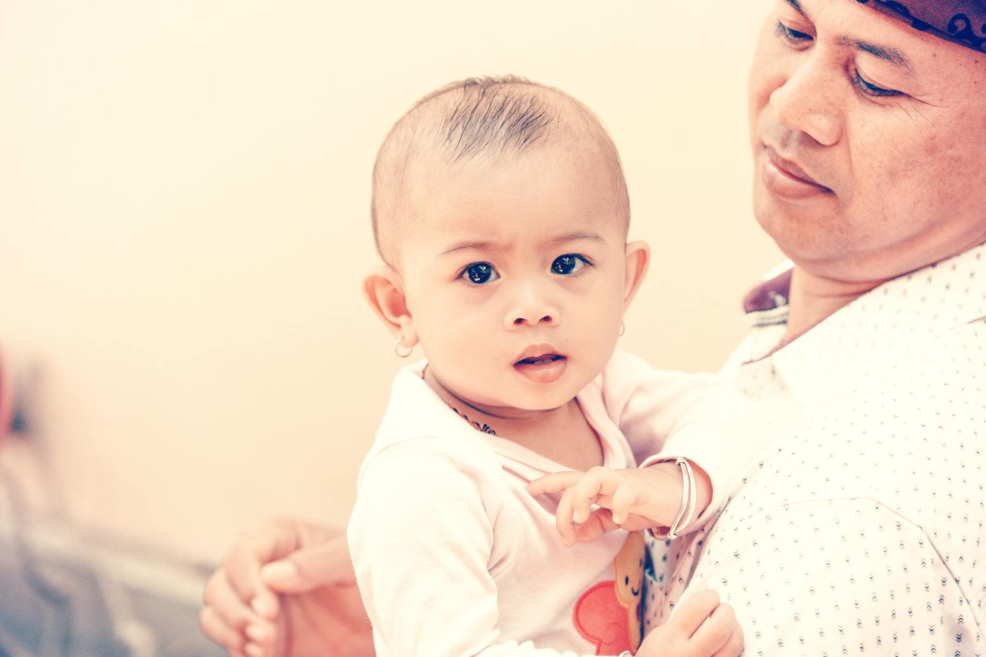 A man is holding a baby in his arms.
