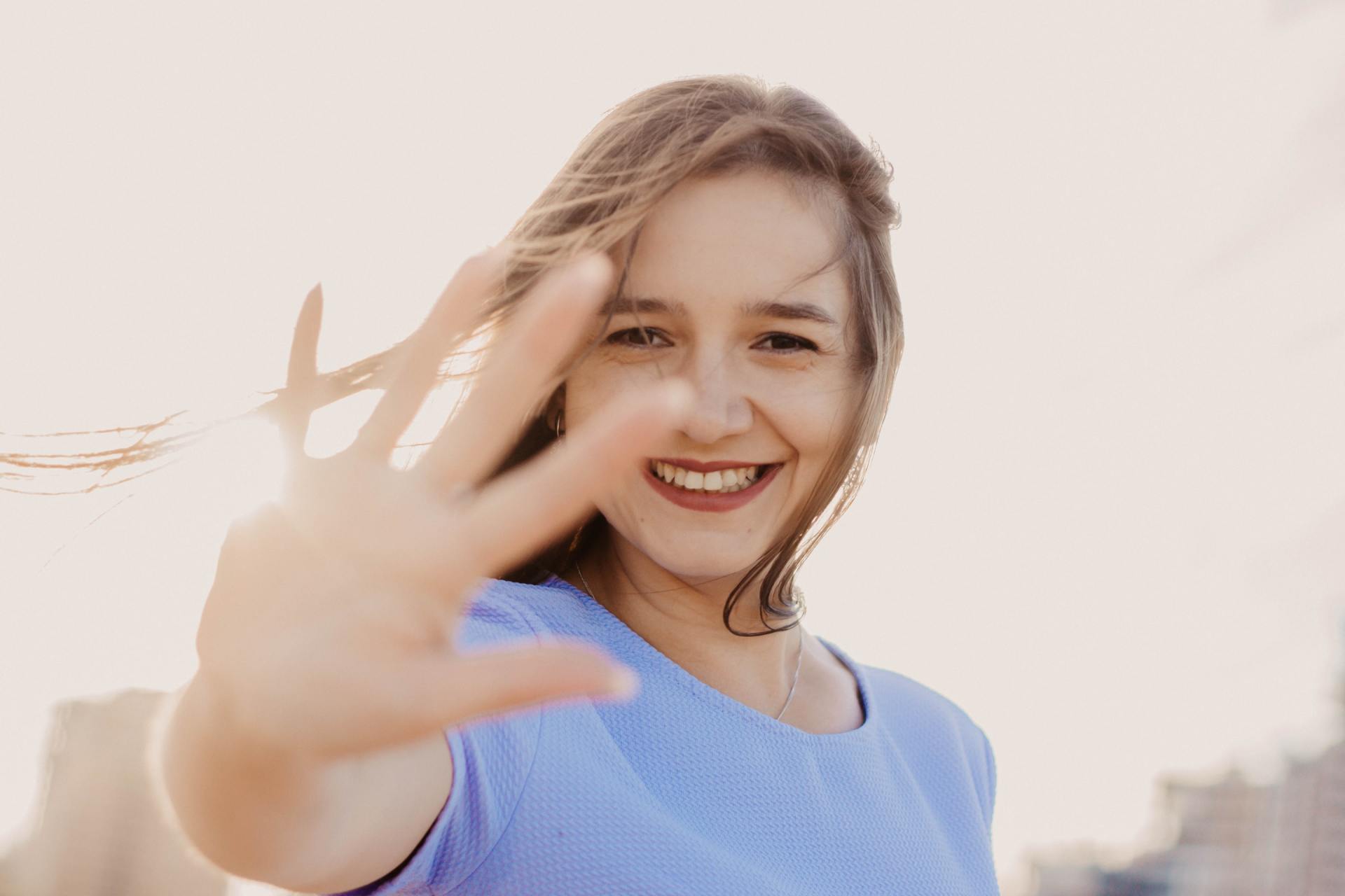 Young-girl-outside-with-hand-up