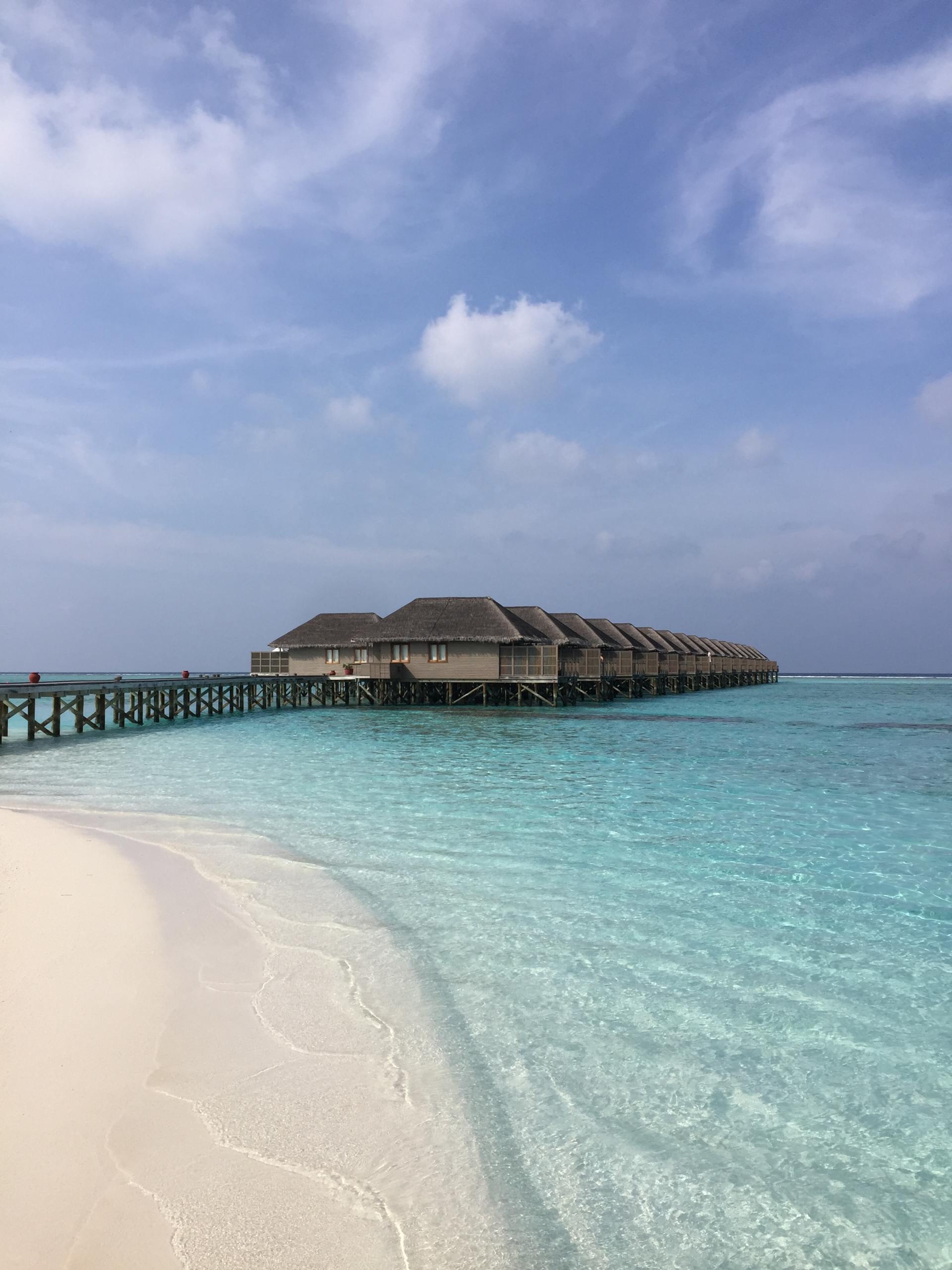 Eine Reihe von Bungalows auf einem Dock mitten im Ozean.